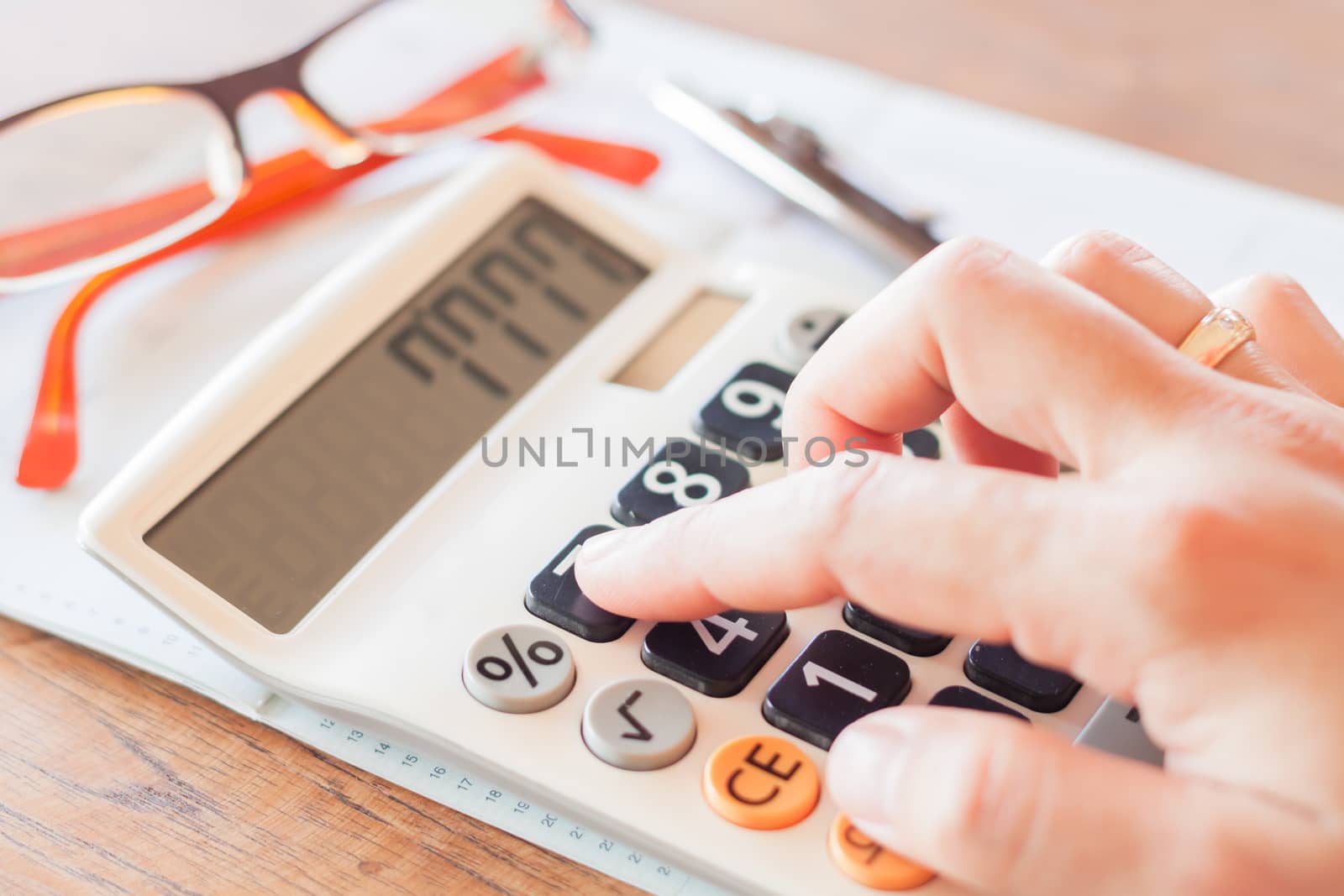 Businesswoman working in coffee shop with calculator, stock photo