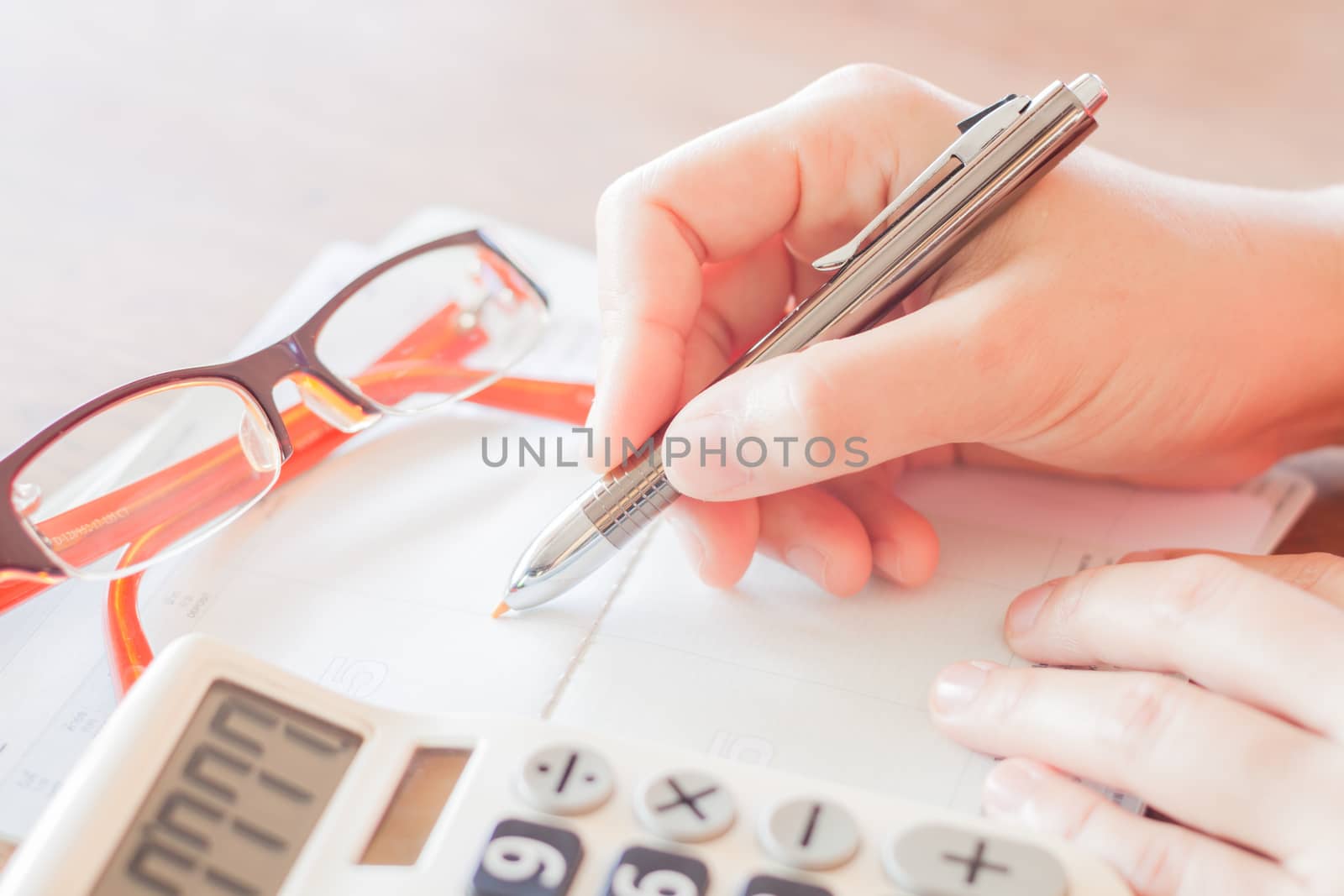 Businesswoman working with calculator and pen by punsayaporn