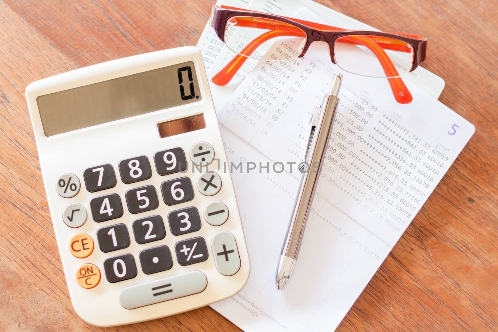 Top view of calculator, pen, eyeglasses and bank account passbook, stock photo