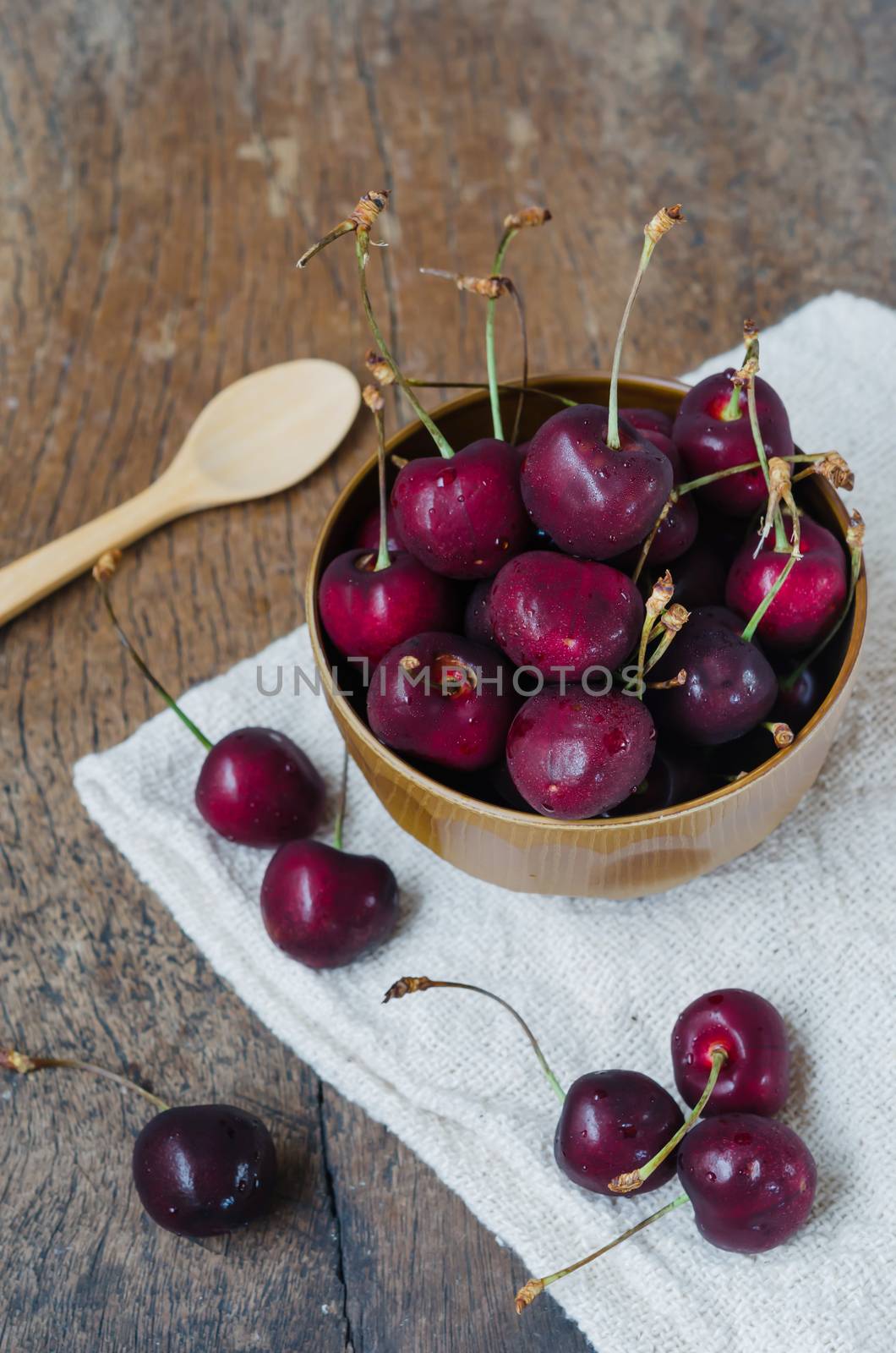 fresh cherries in bowl ,  on wooden table  background