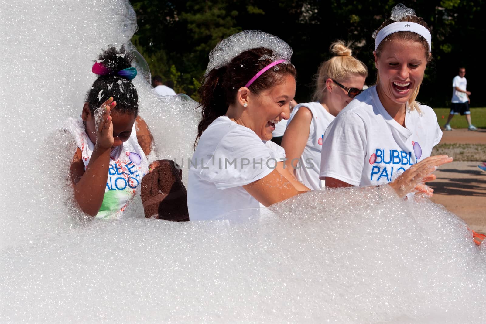 Women Laugh Walking Through Foamy Soap Suds At Bubble Palooza  by BluIz60
