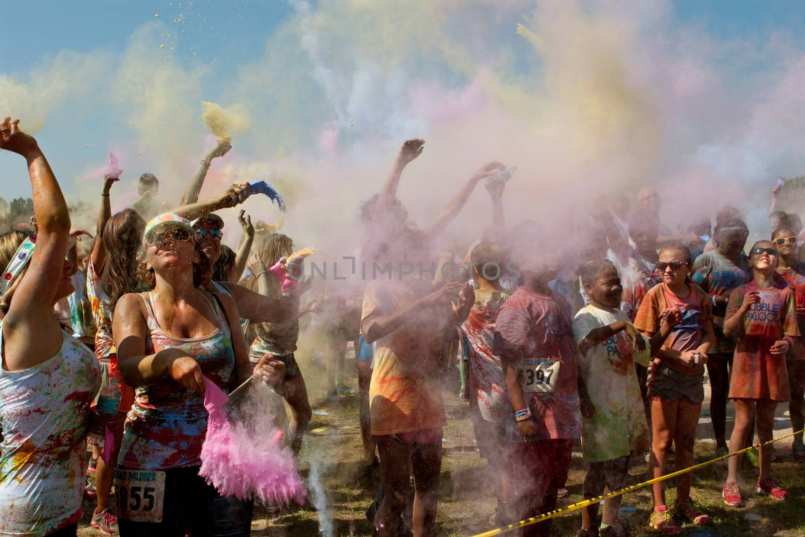 Lawrenceville, GA, USA - May 31, 2014:  People throw packets of colored corn starch in the air to get doused in color at Bubble Palooza.