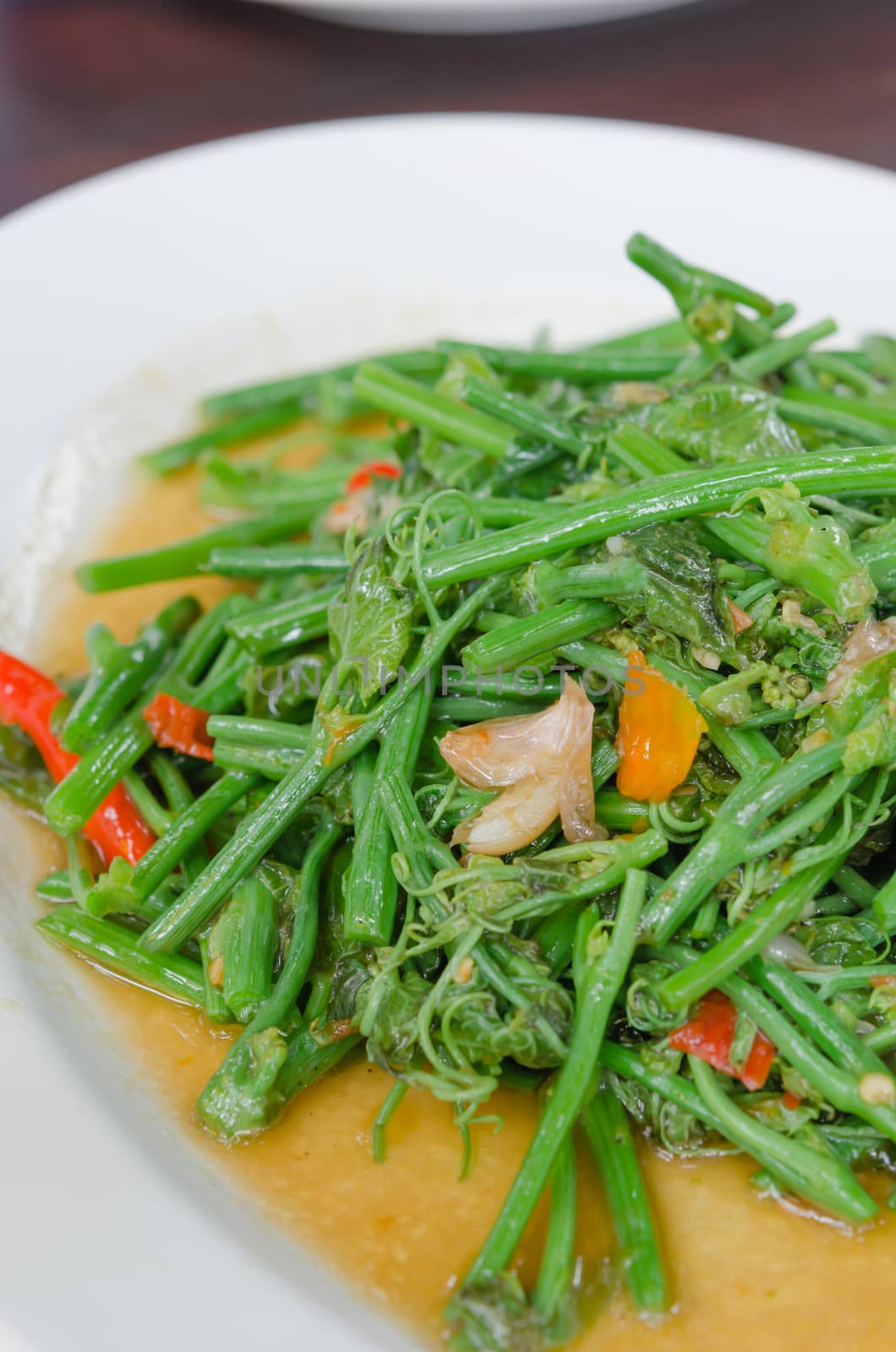 close up stir fried chayote with chili on white dish