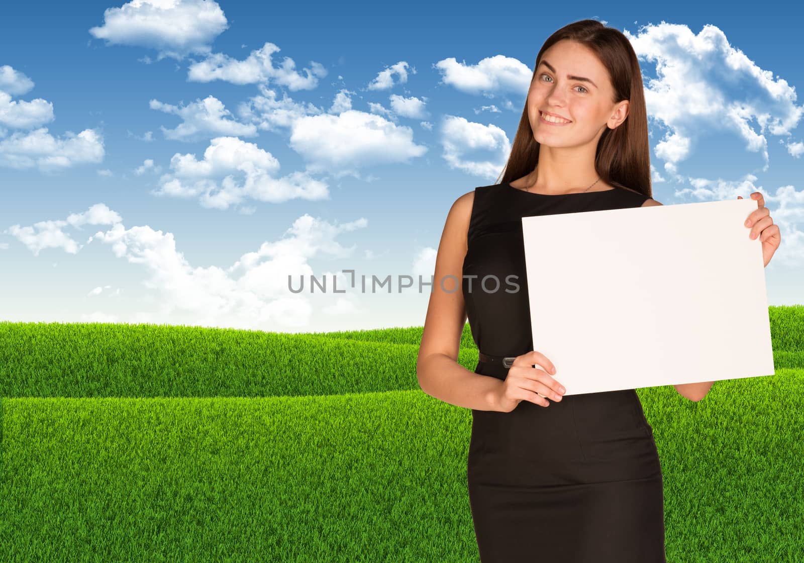 Businesswoman holding paper sheet. Blue sky and green grass as backdrop