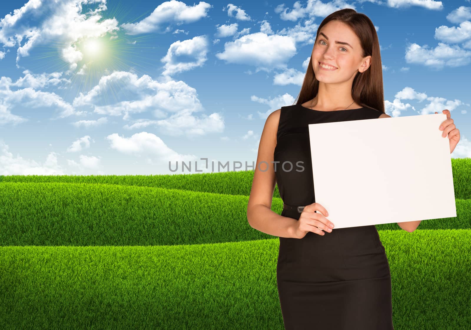 Businesswoman holding paper sheet. Blue sky and green grass as backdrop