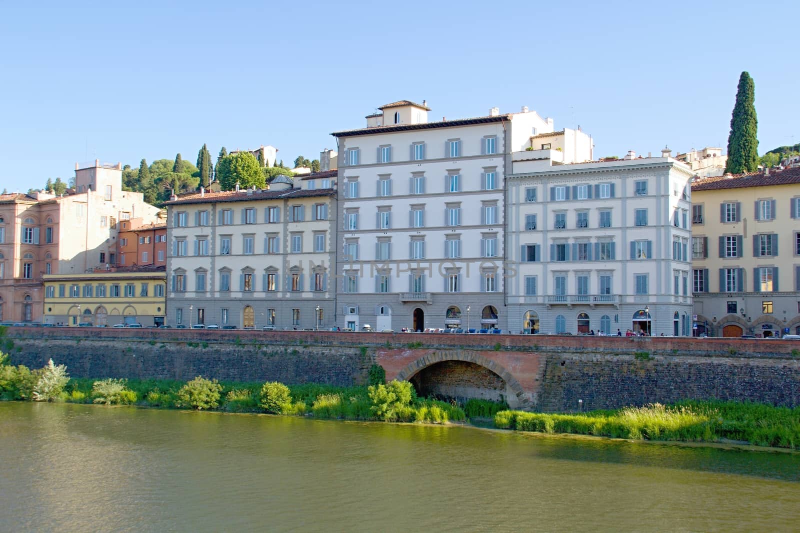 Photo shows a general view onto the city river bank with its houses.