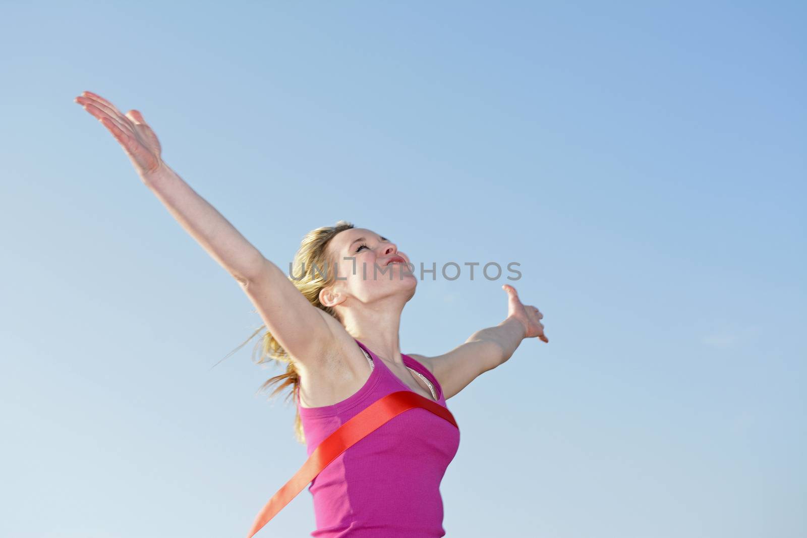 young blond woman  crossing finishing line