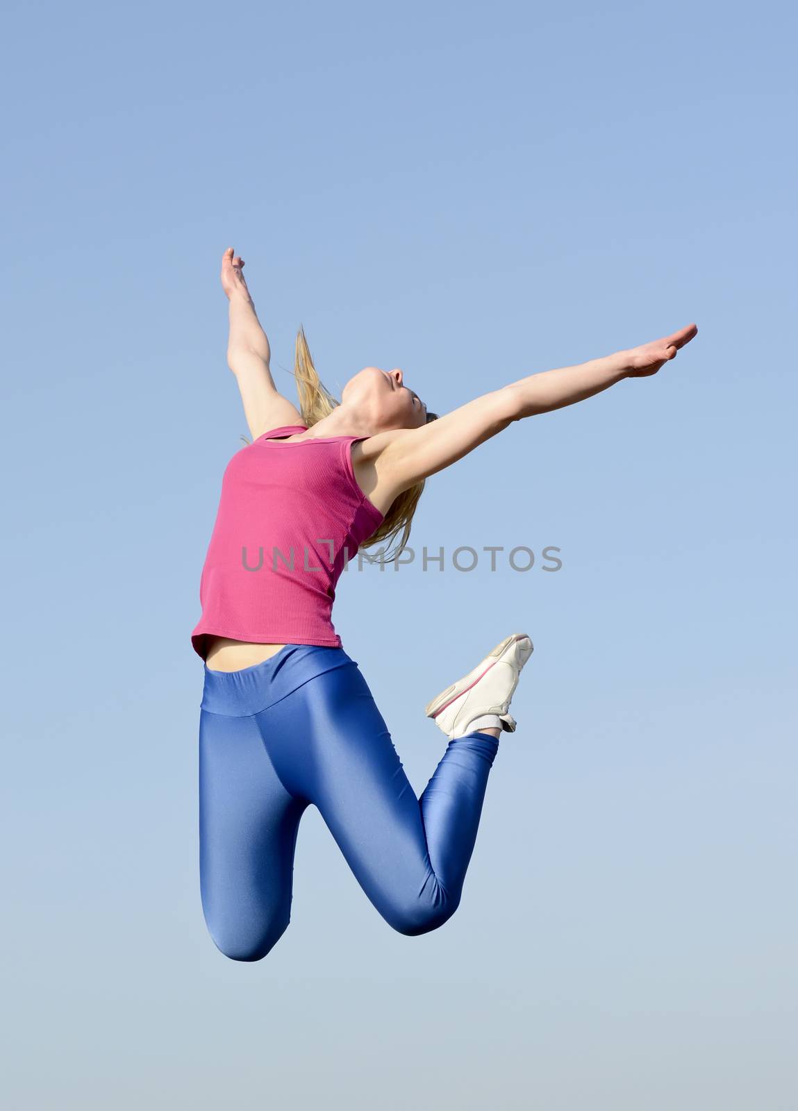 joyful young blond woman leaping