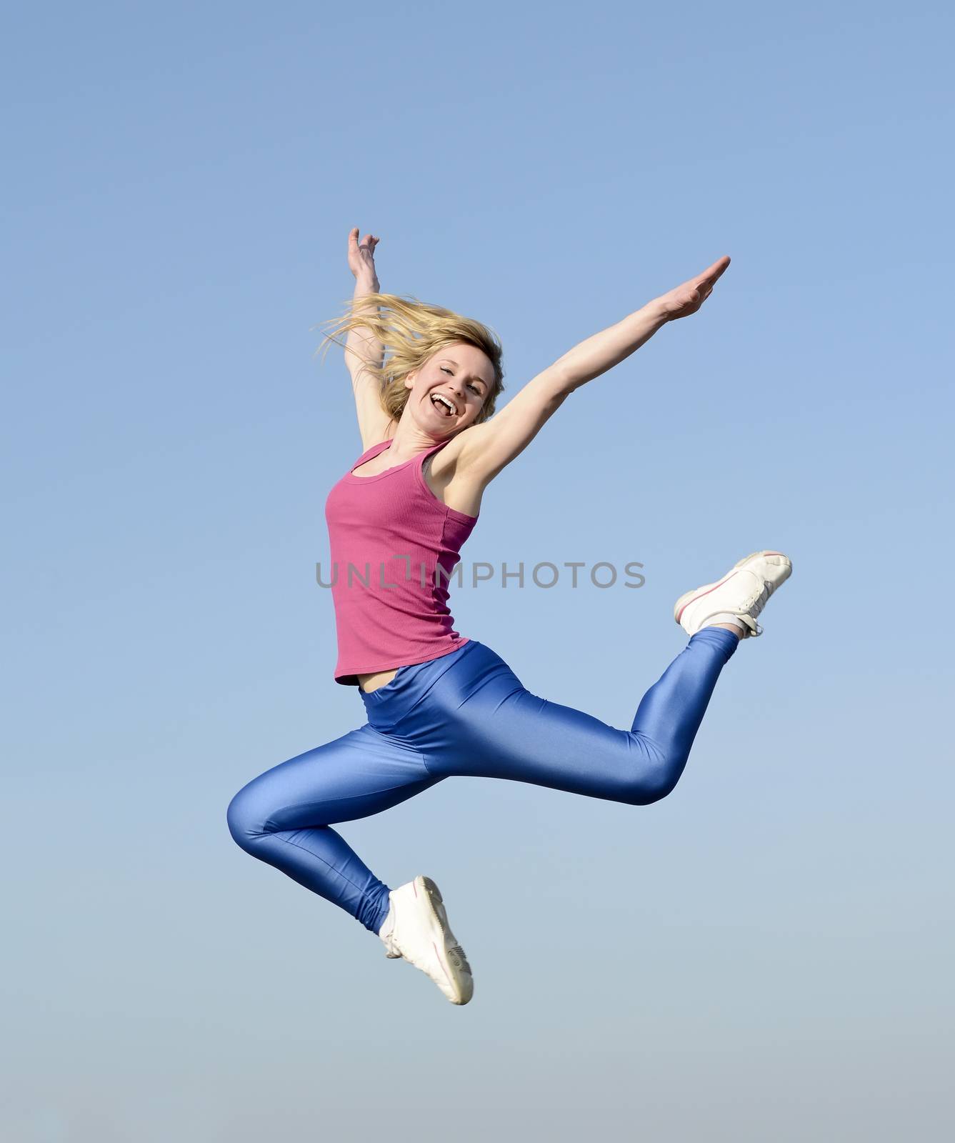 joyful young blond woman leaping