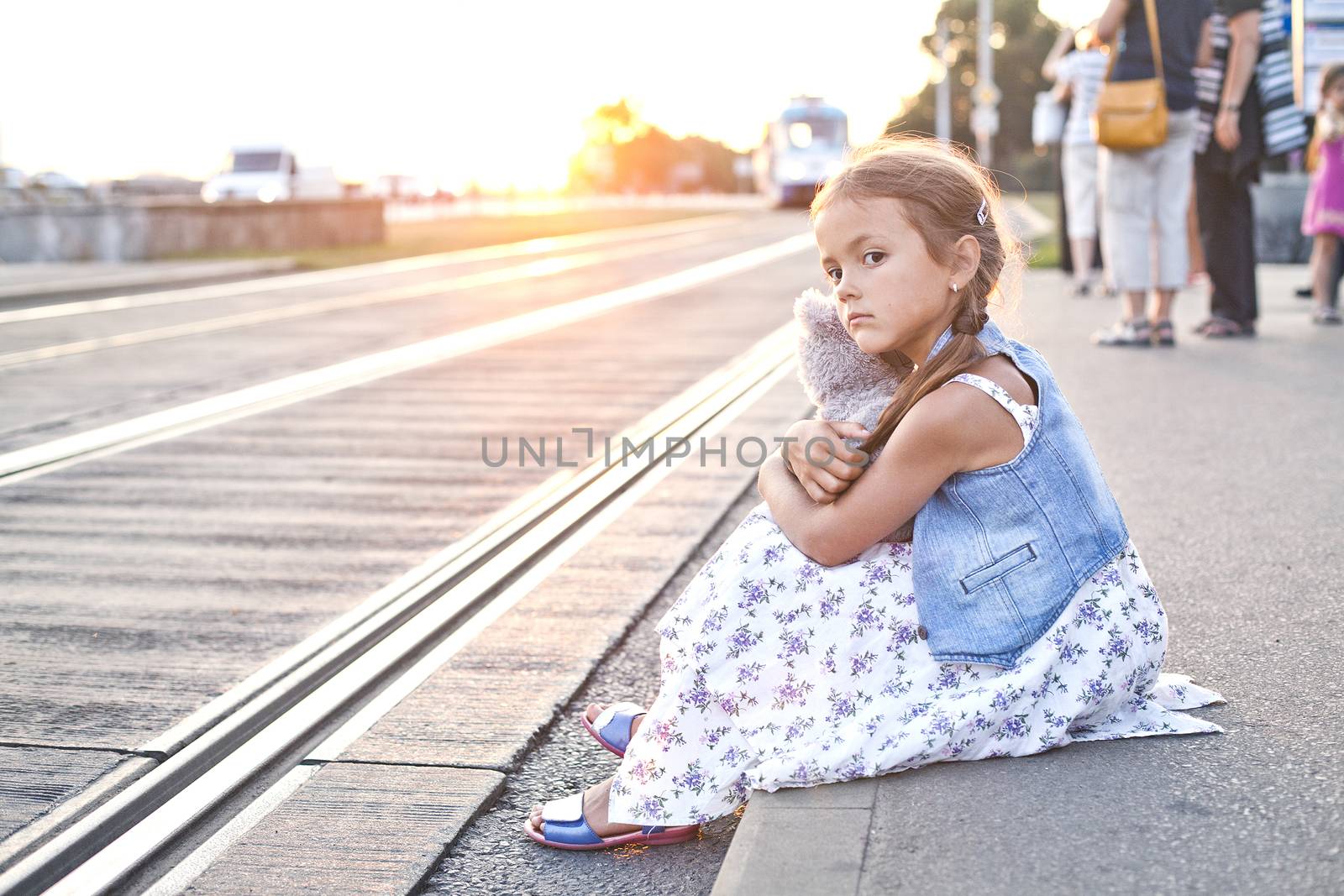 Lonely girl on a city tram station by Kor