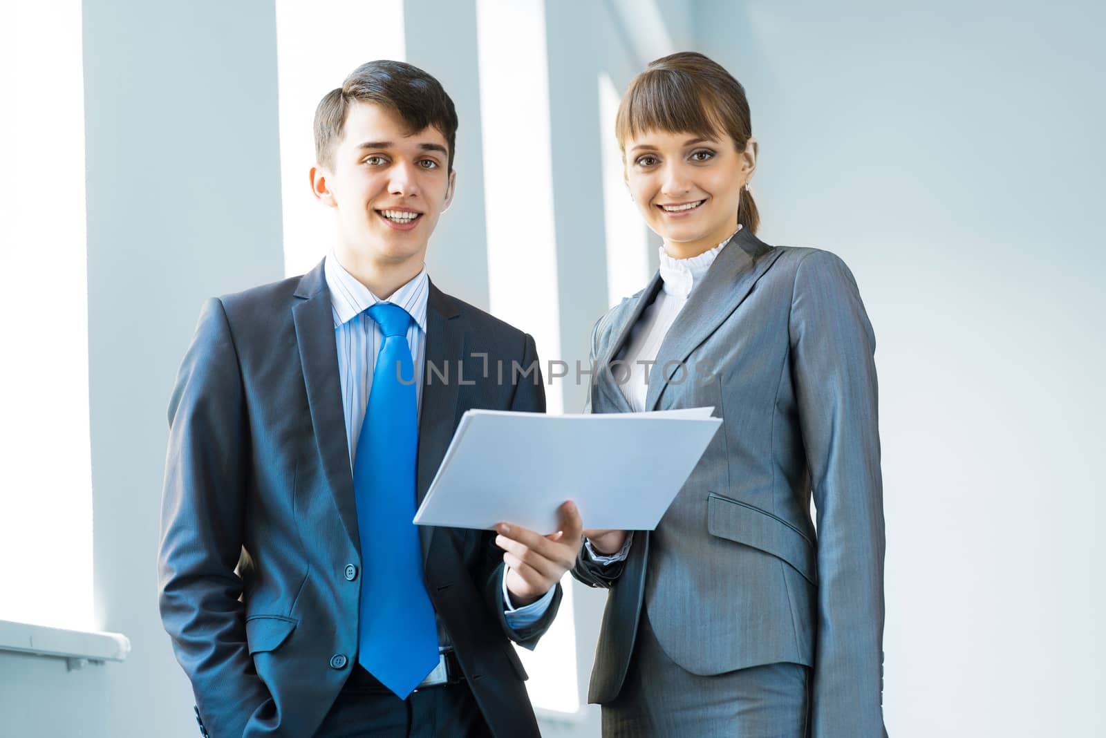 two business partners discussing documents in a bright office