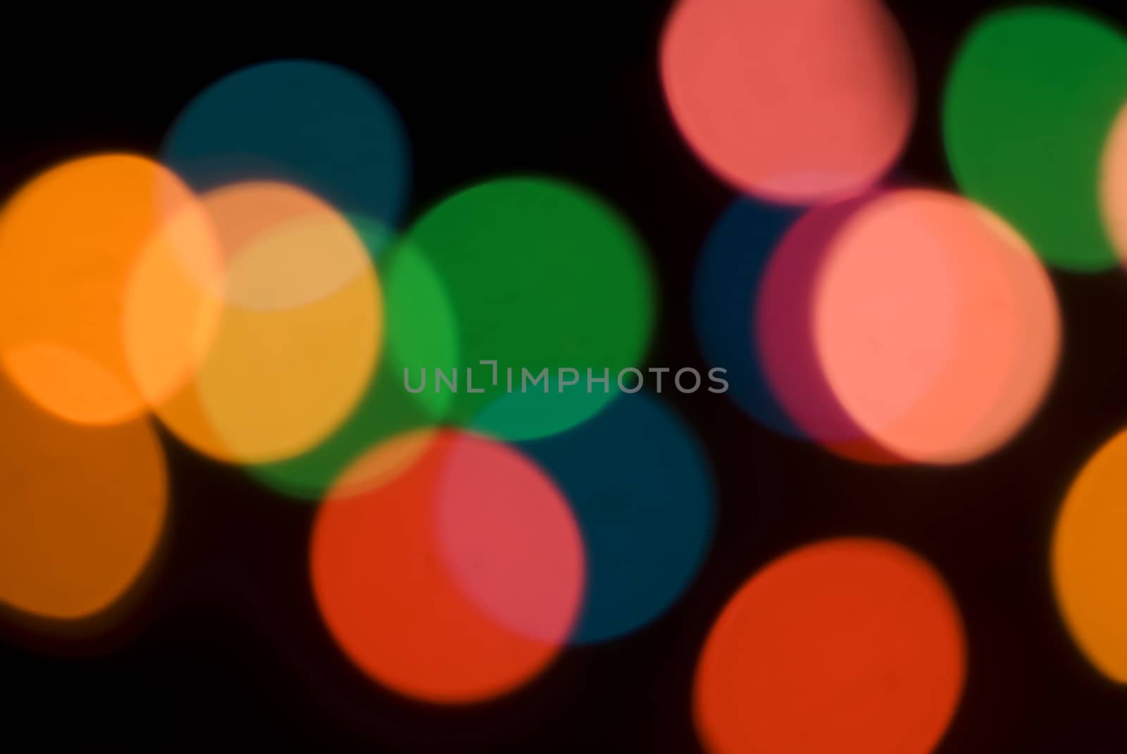 Bokeh of colorful party lights in red, orange and green for a festive background for a celebration or holiday