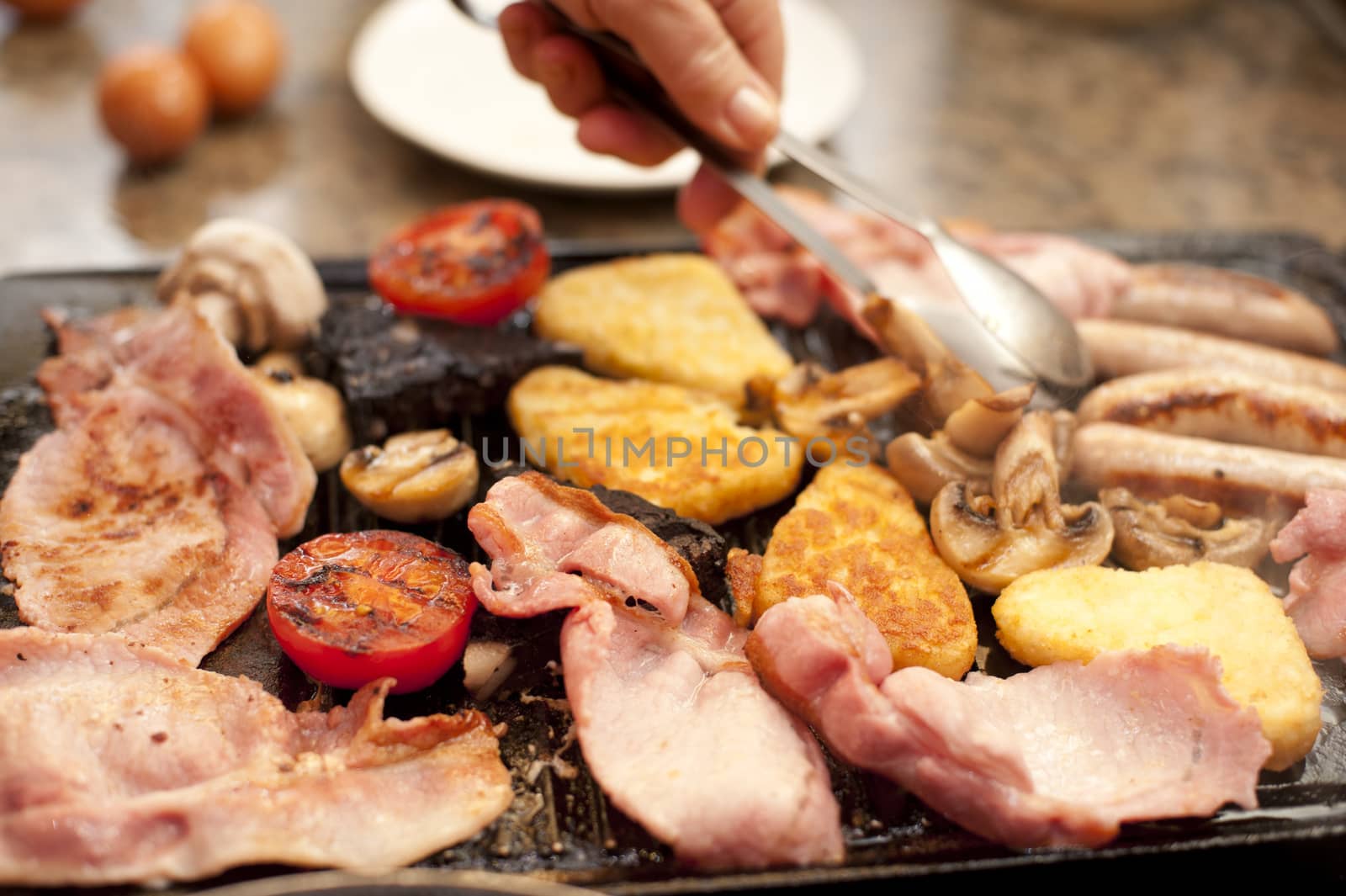 Man serving a hearty cooked breakfast by stockarch