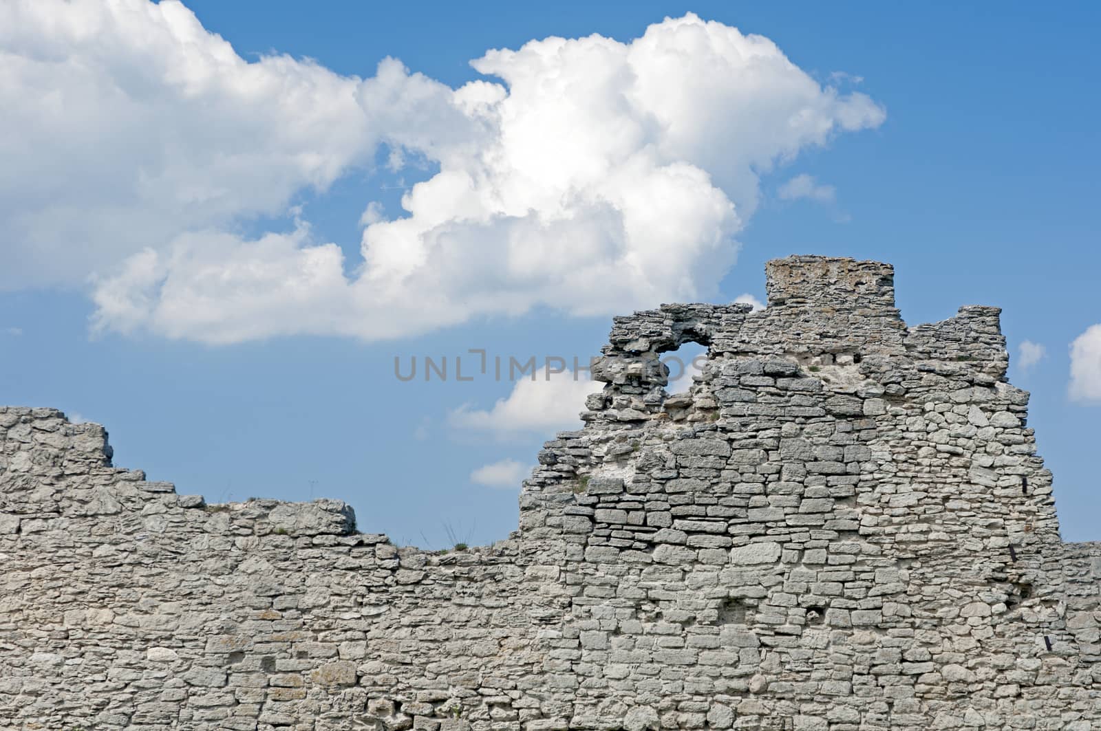 Ruins of old fortress wall and cloudy sky