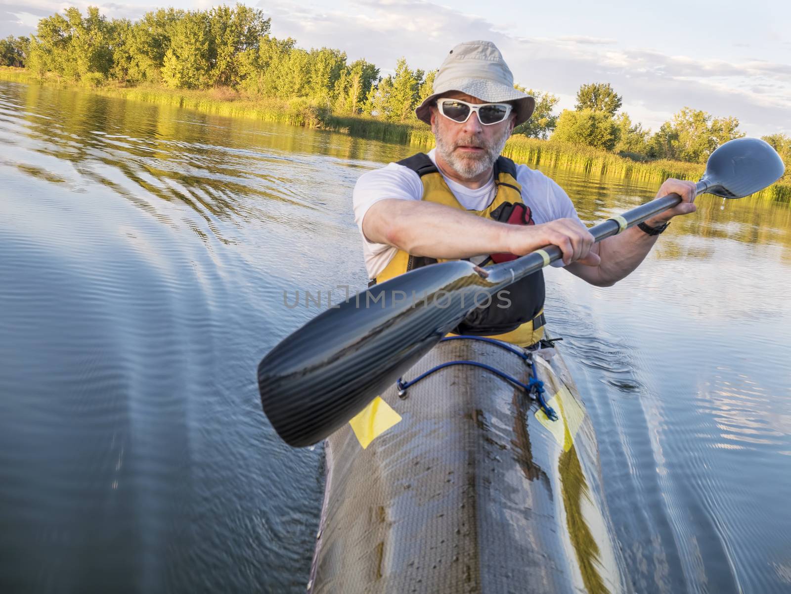 senior male paddler training in a fast sea kayak used in adventure racing - bow view