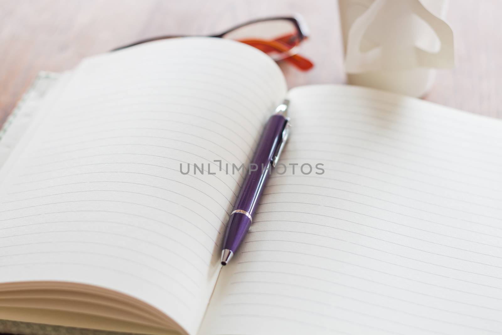 Pen and notebook on wooden table, stock photo