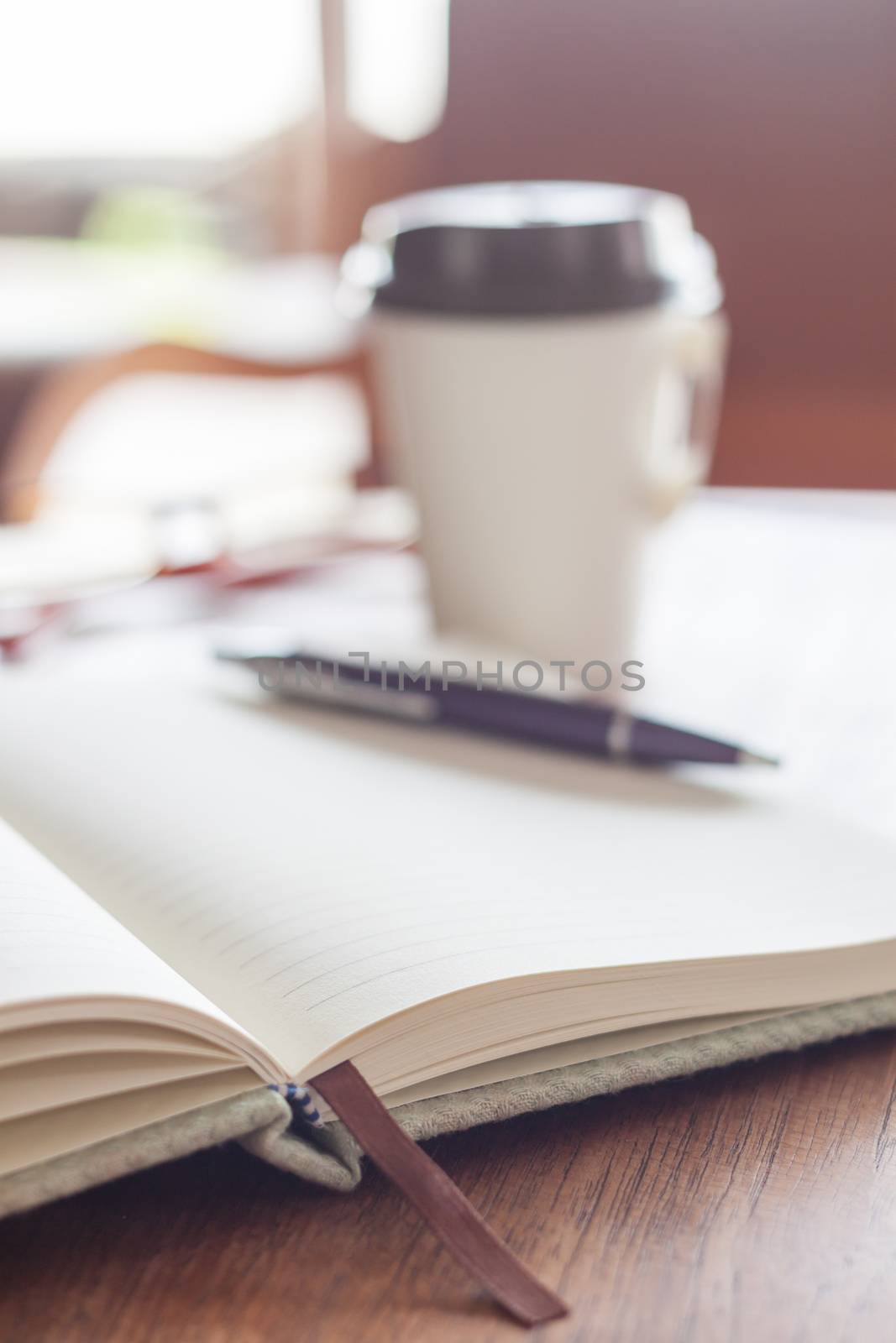 Open notebook with pen and coffee cup by punsayaporn