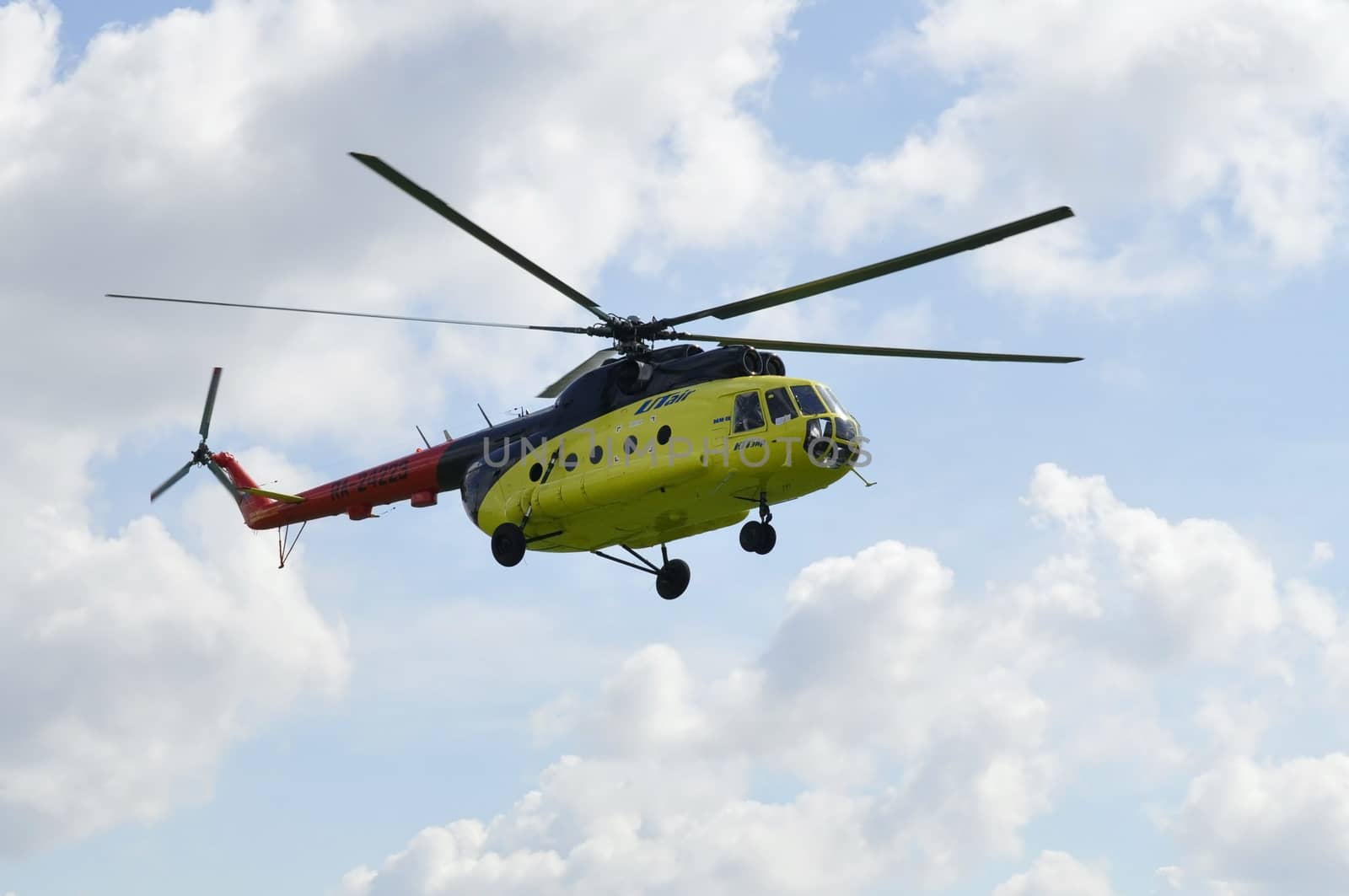 The yellow MI-8 helicopter flies against clouds. by veronka72