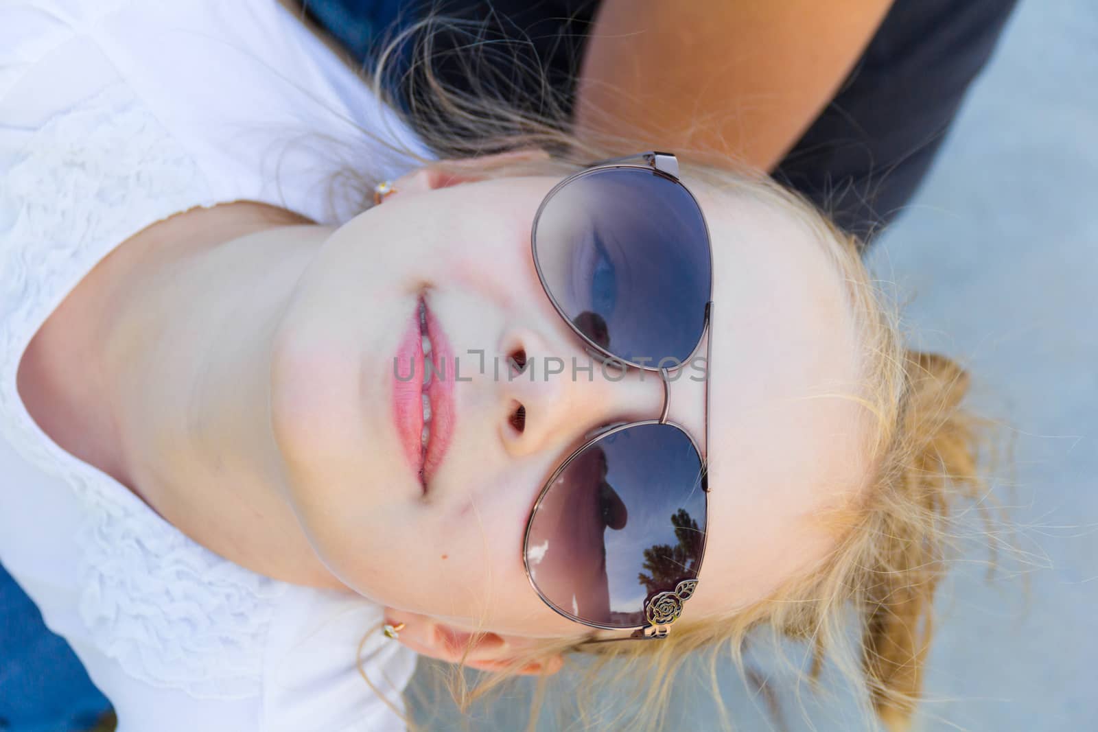 Cute girl with blond long hair in sunglasses