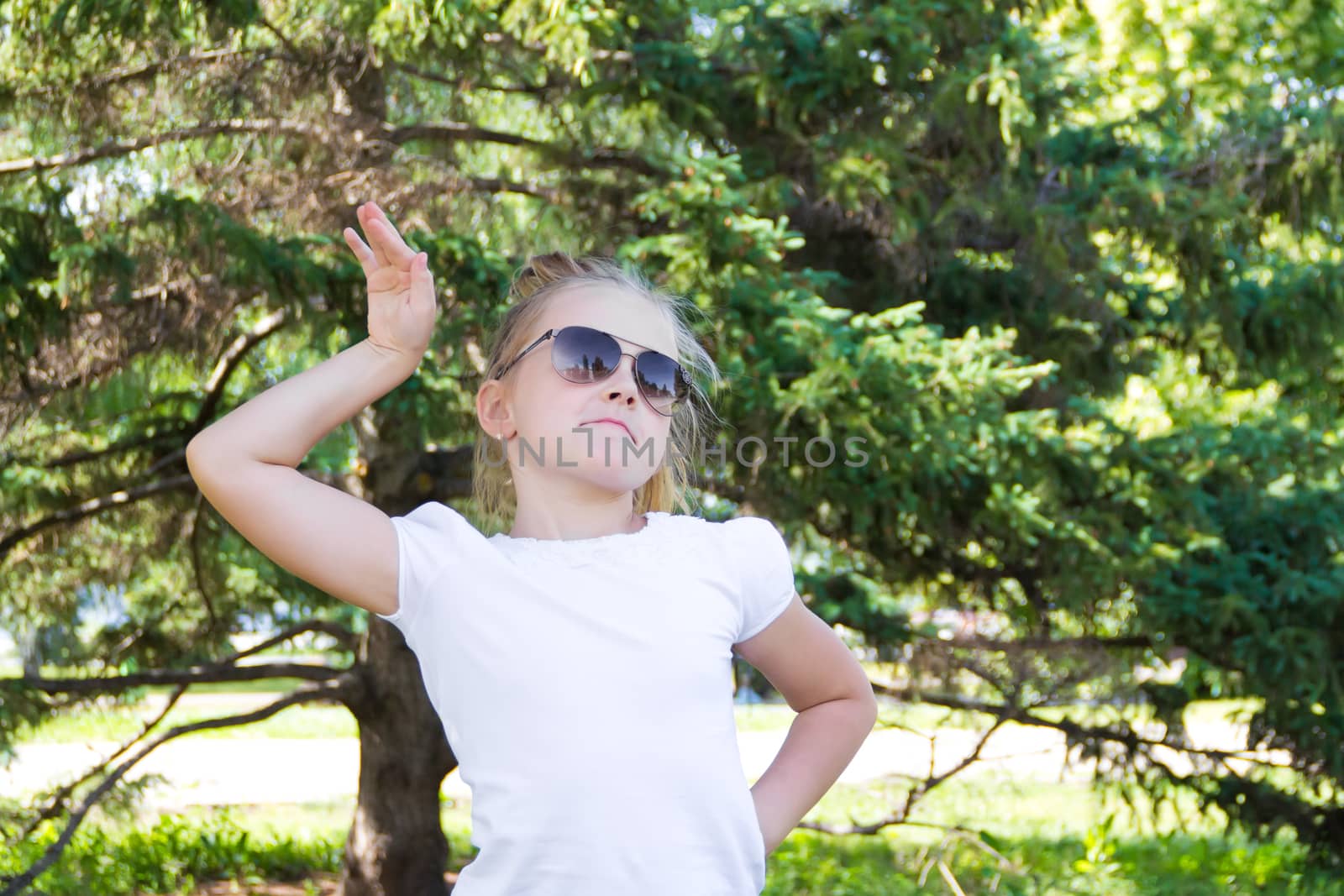 Cute girl playing with sunglasses in summer