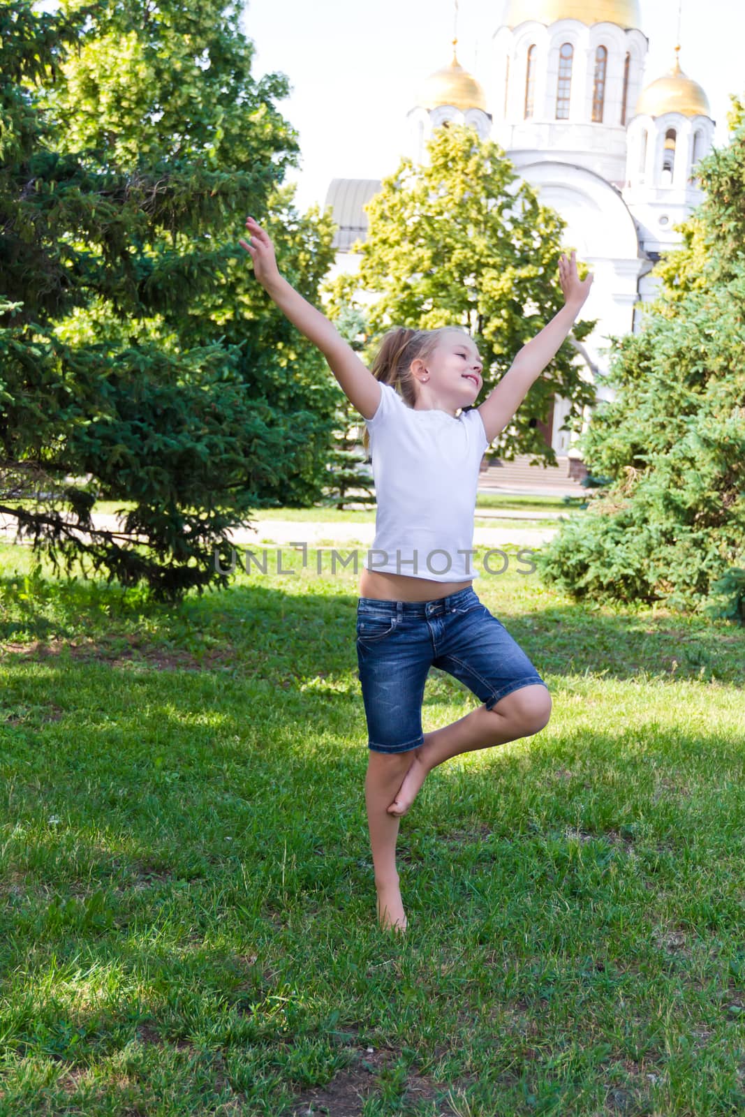 Cute girl with blond hair jumping on one leg