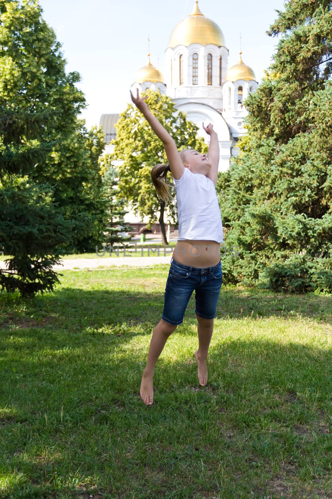 Cute jumping girl with blond hair in summer