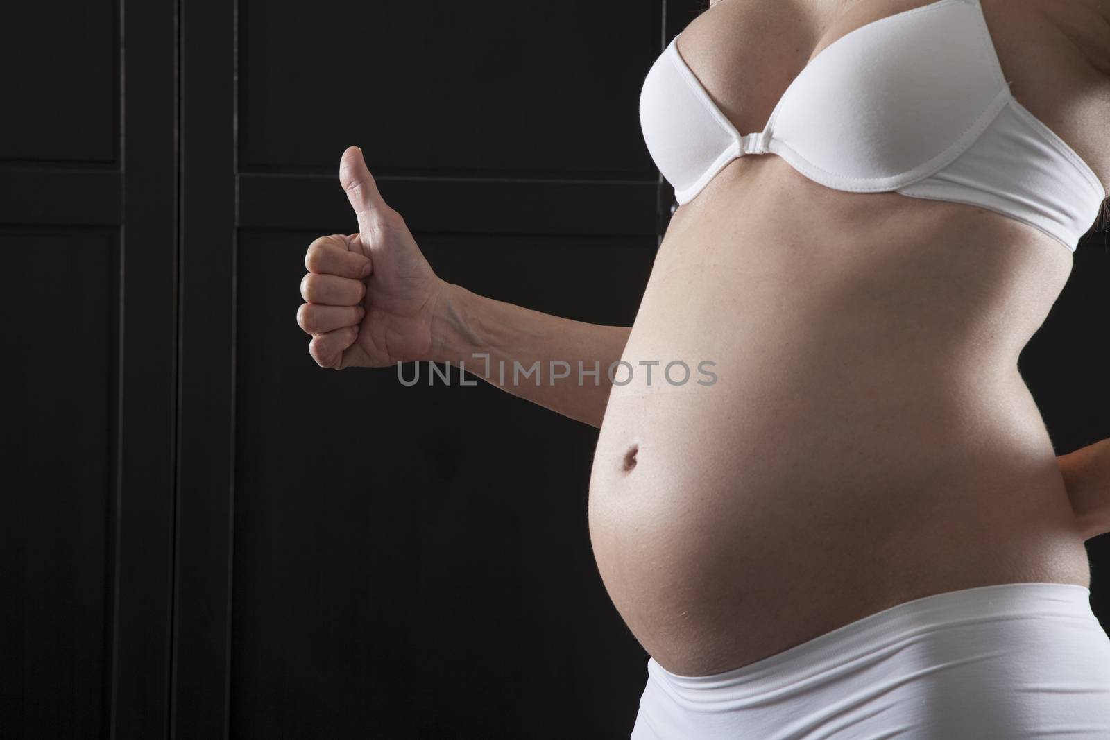 naked pregnant woman belly with white bra and panty
