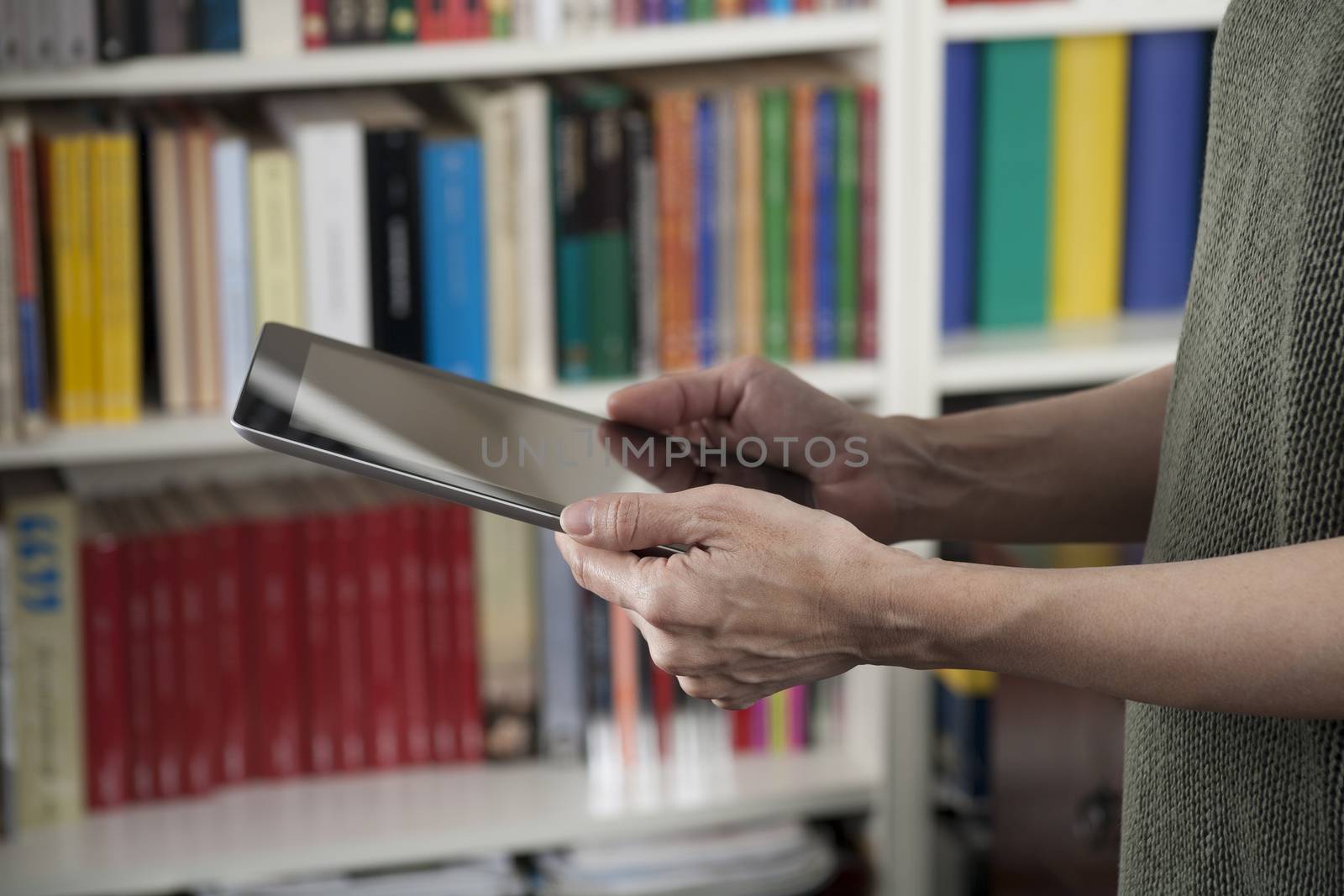 blank screen tablet in woman hands at library