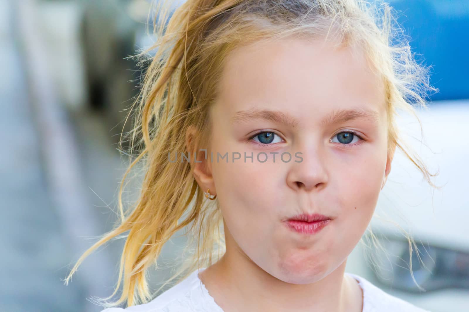 Cute girl with blond long hair and blue eyes