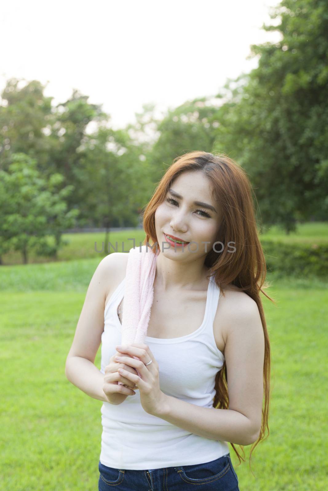 Woman standing rest after jogging. On lawn in the park