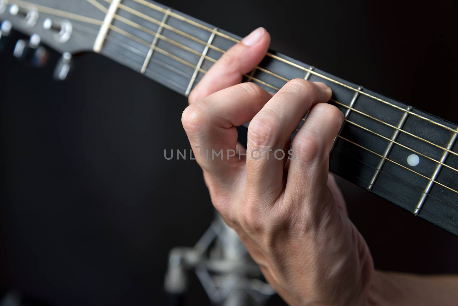 Close-up of the fingering for a G major chord on a left handed classical guitar.