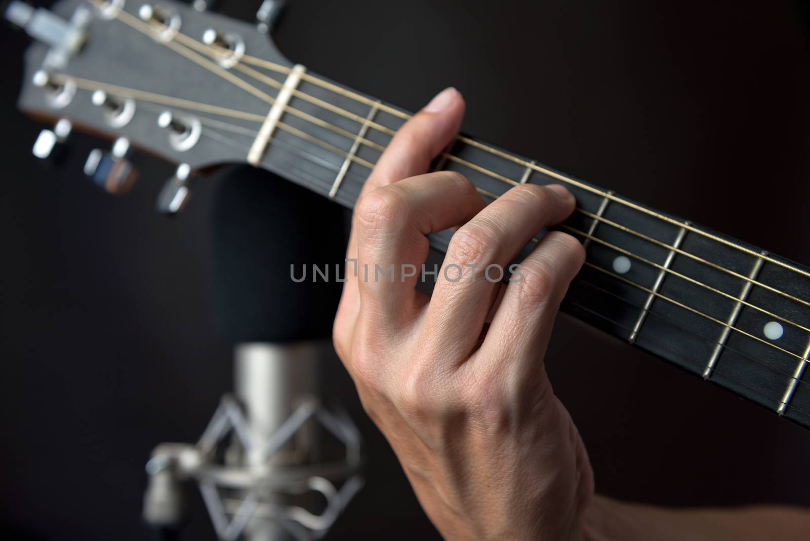 Close-up of the fingering for an F sharp chord on a left handed classical guitar.