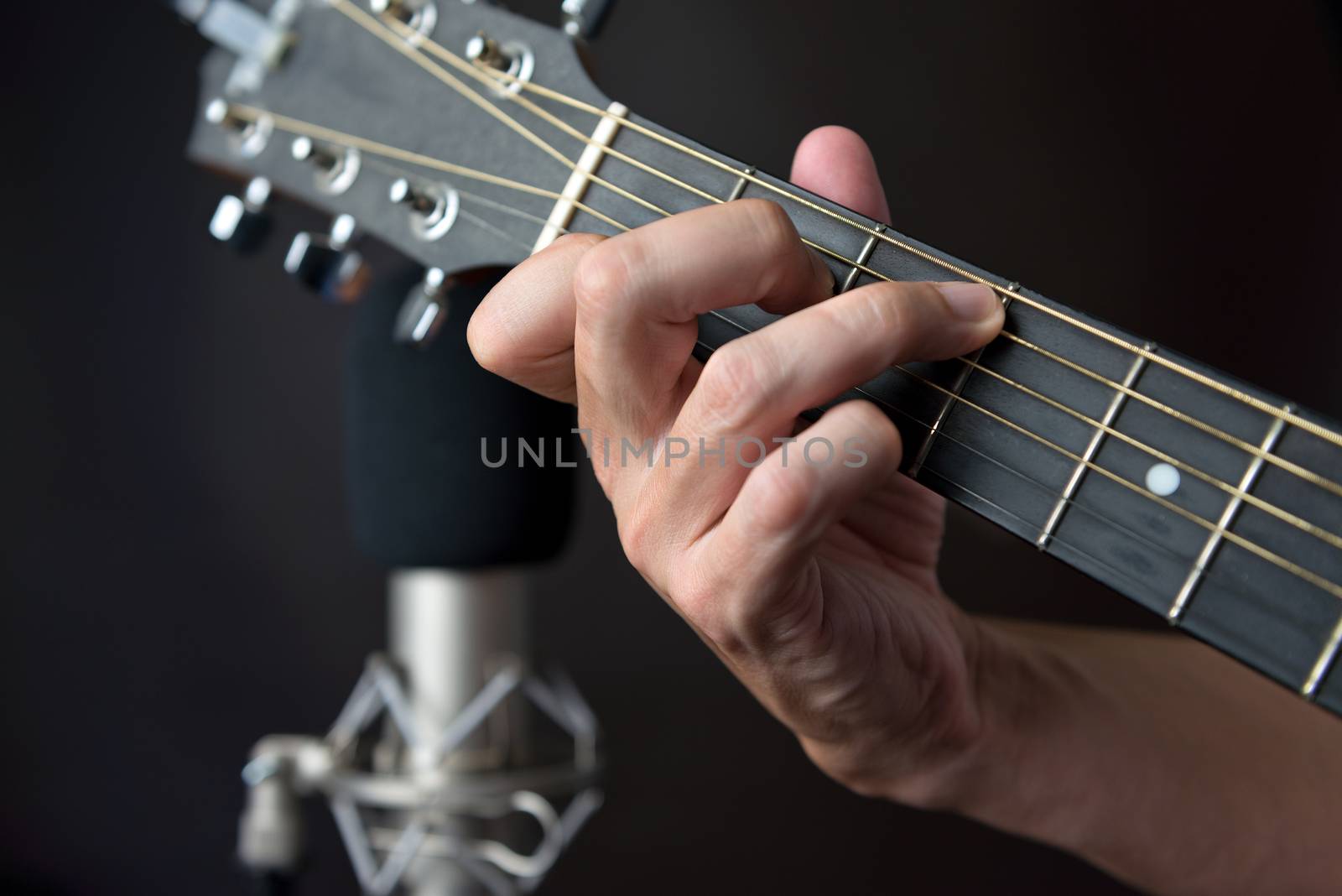 Close-up of the fingering for a C7 sustained chord on a left handed classical guitar.