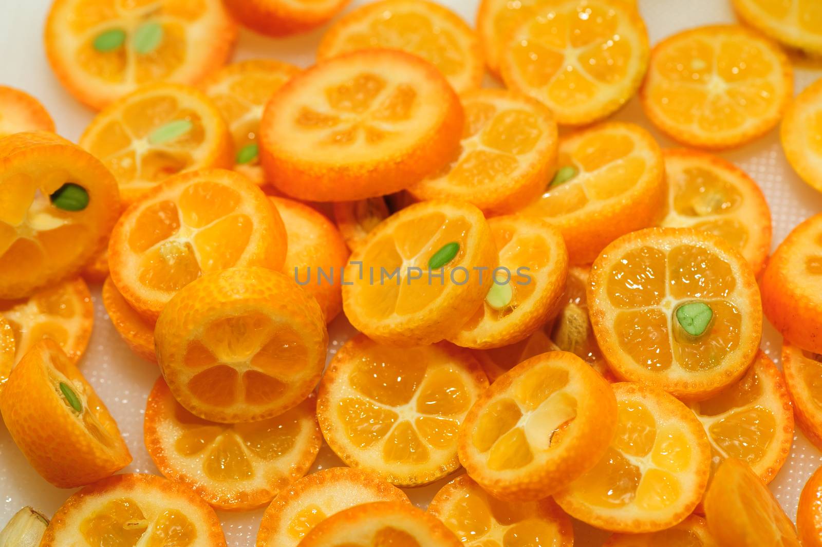 tray full of ripe kumquat slices, suitable as background