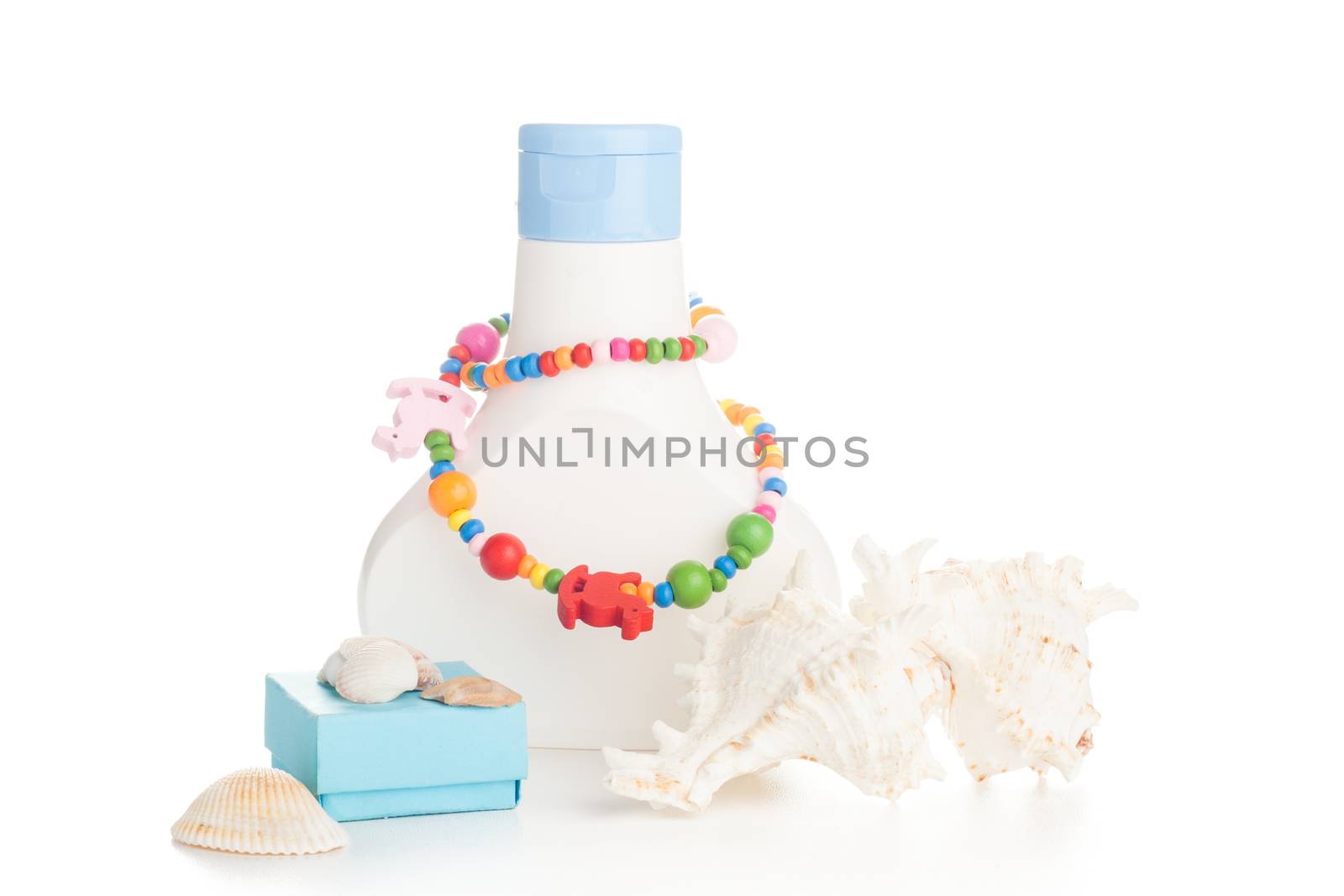 white lotion bottle with color necklace and seashells