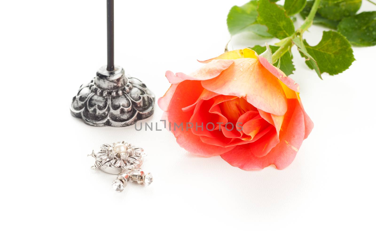 orange rose with silver jewelry ear rings,  medal