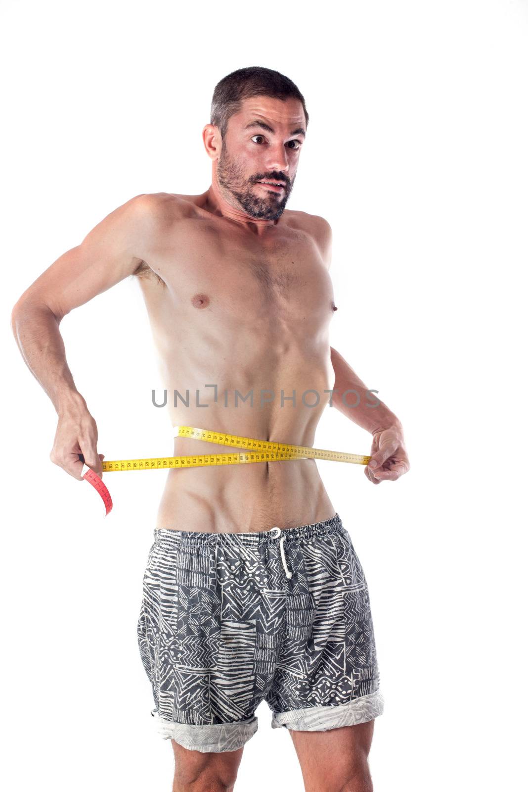 young man measuring in front of white background