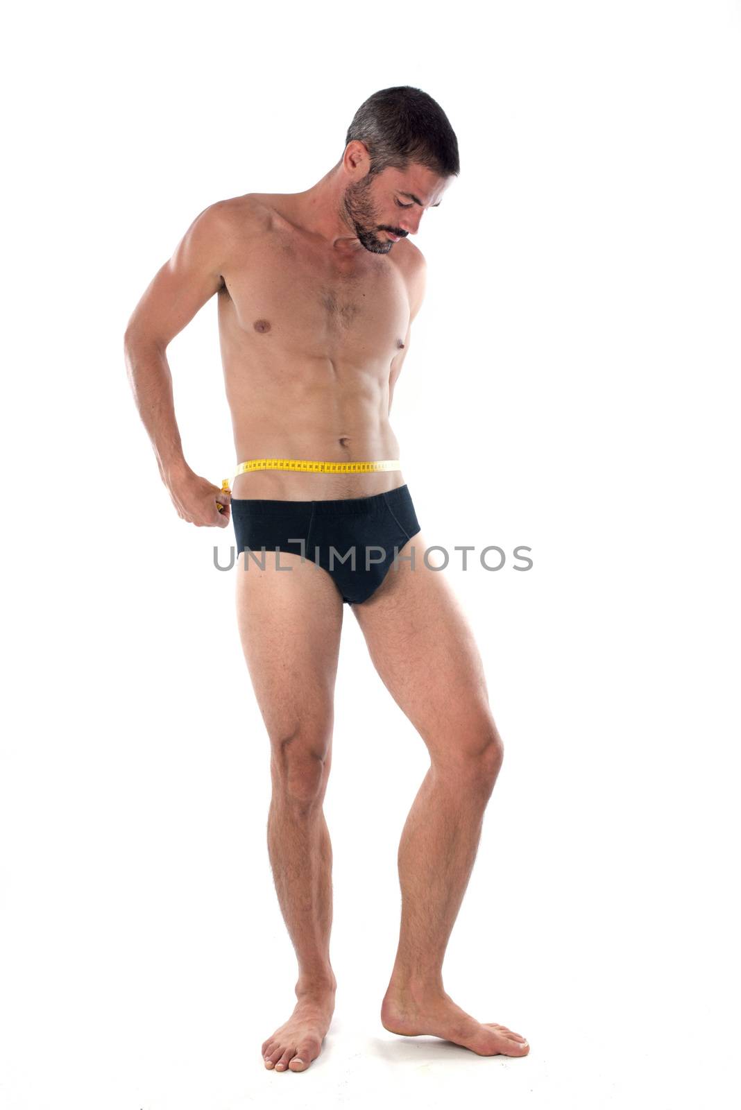 young man measuring in front of white background