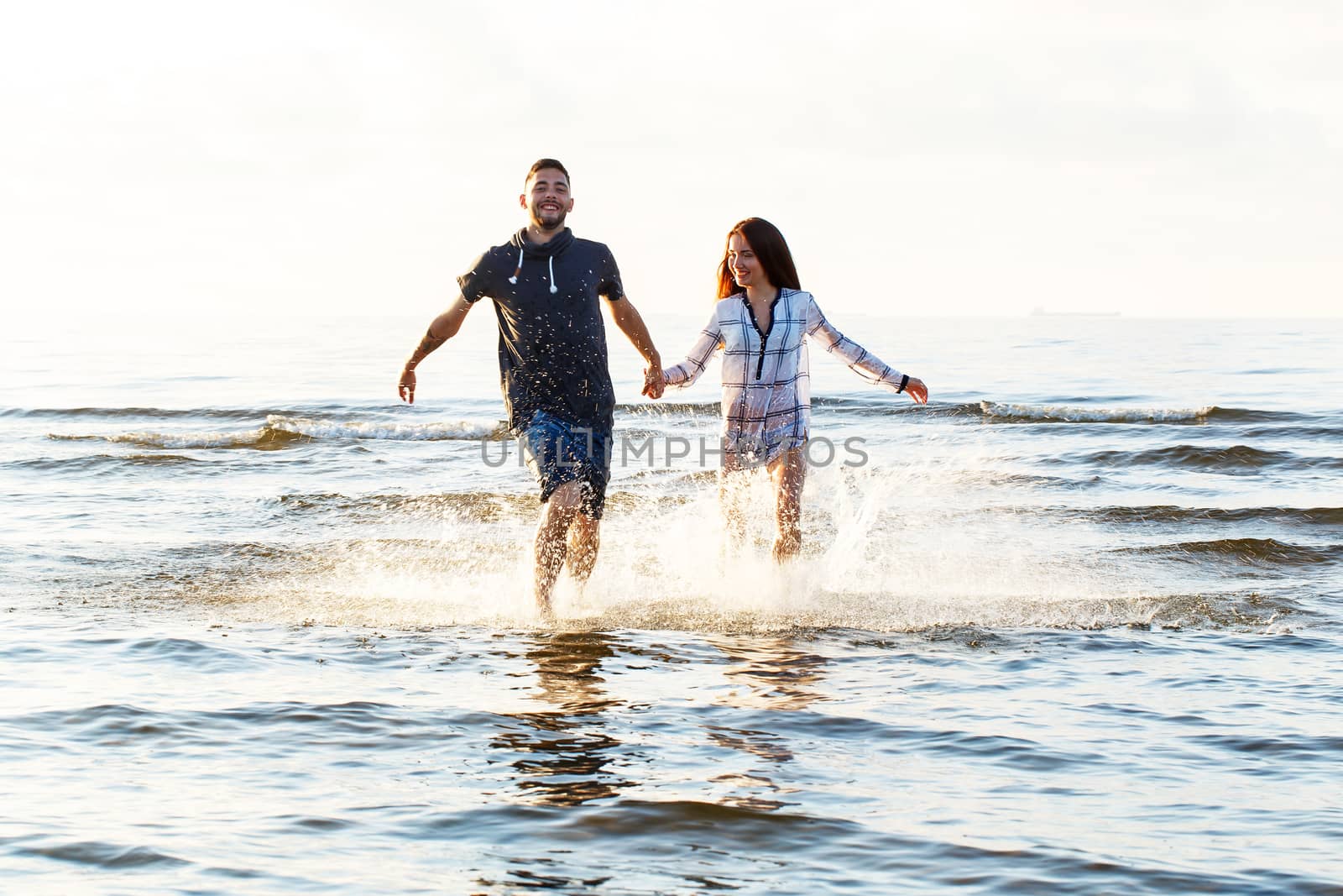 Summer, love. Attractive couple running on the beach