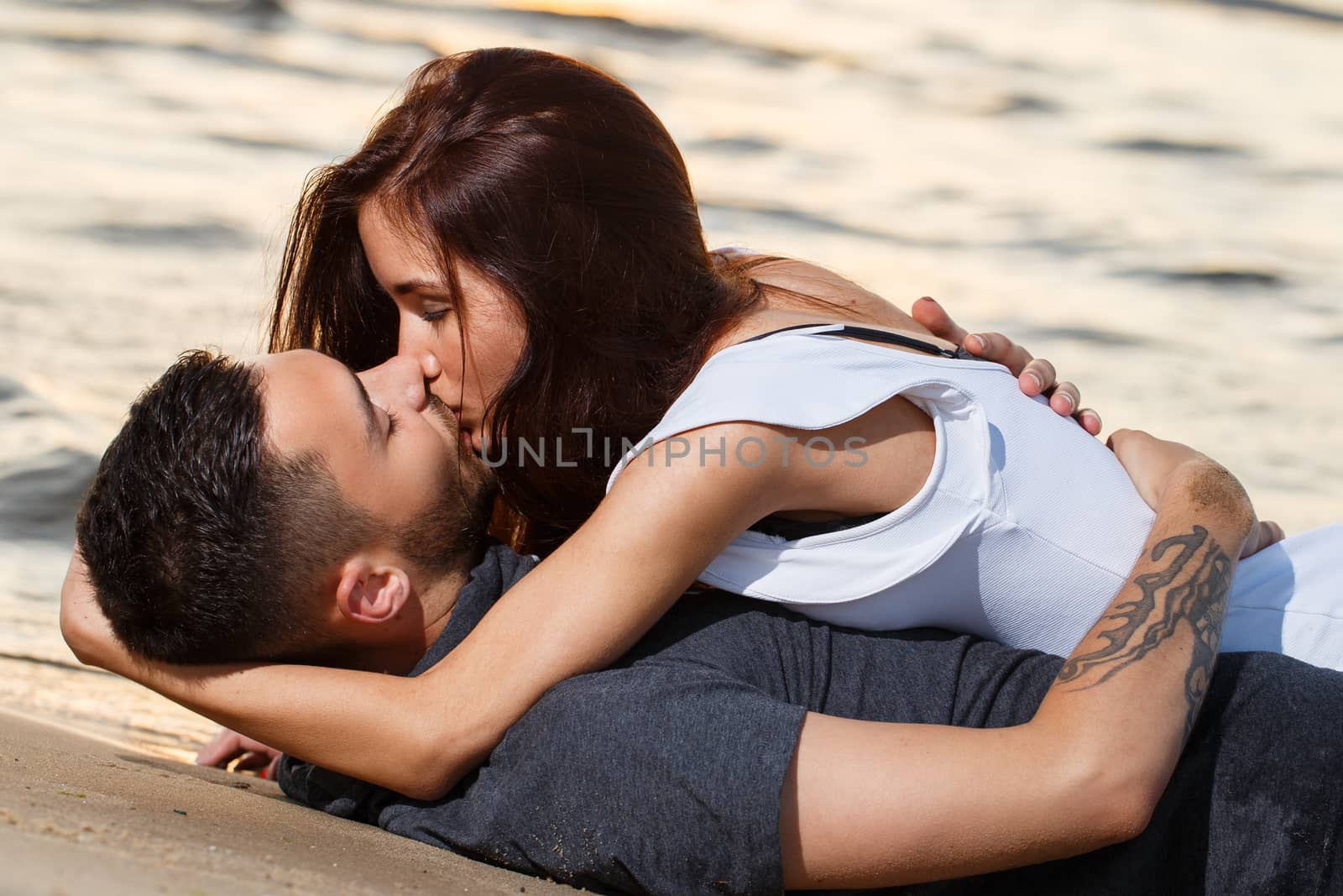 Summer, love. Attractive couple lying on the beach