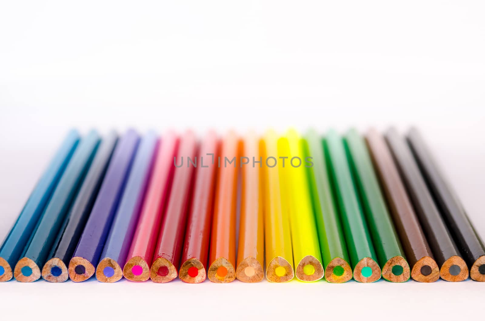 Detail of colorful pencils in a row on white background