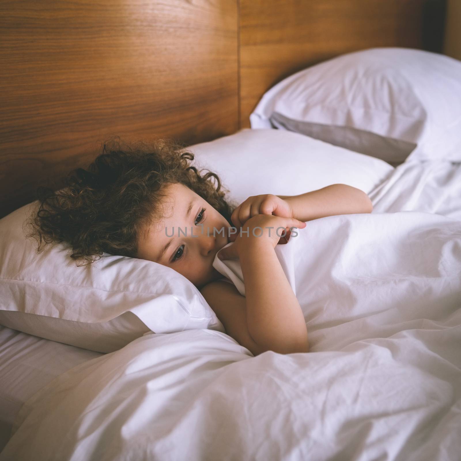 Close-up of a young girl resting in bed at home