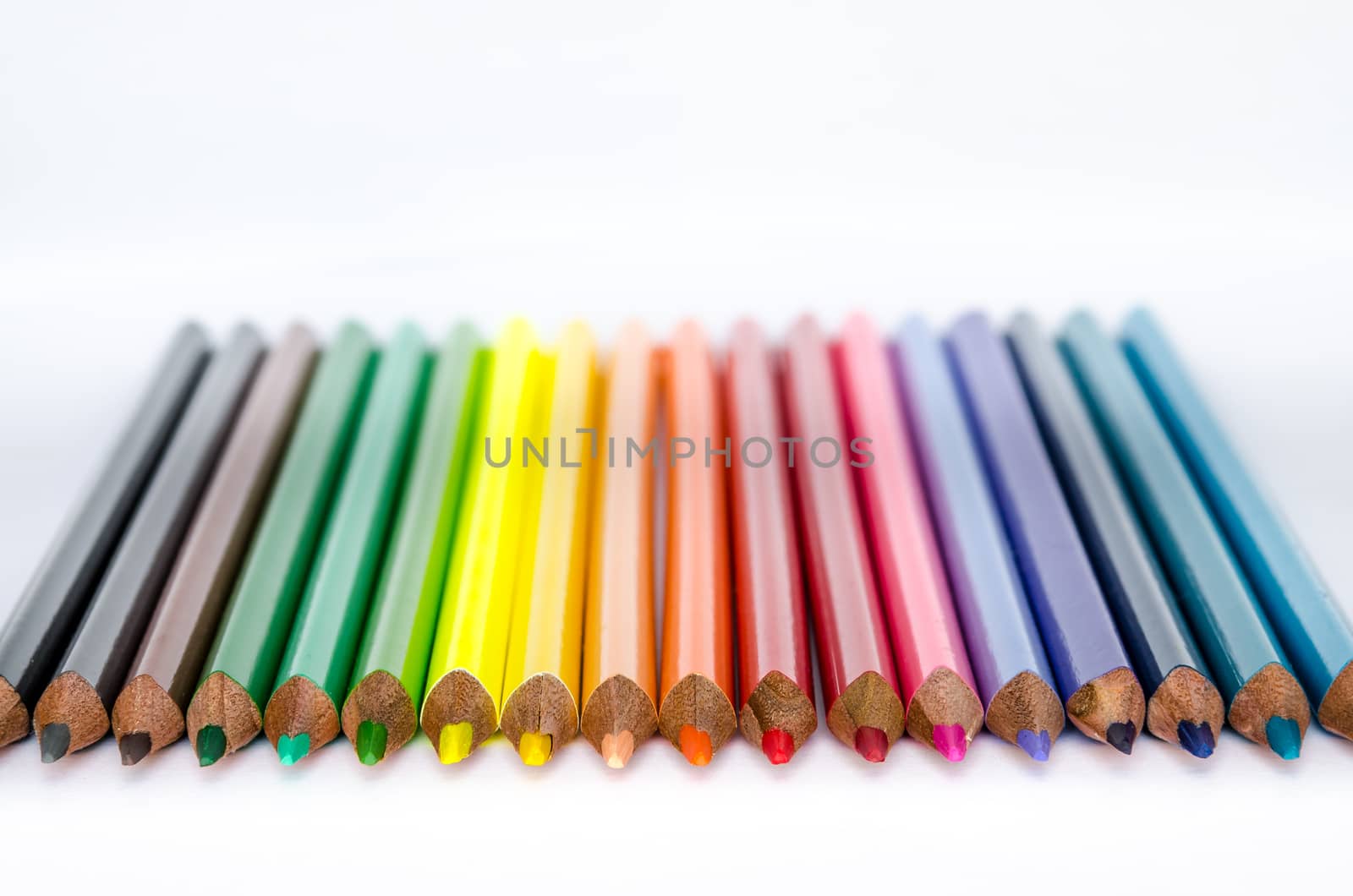 Detail of colorful pencils in a row on white background