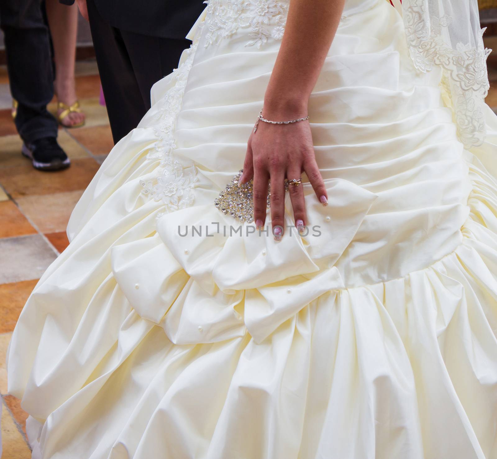 Wedding day. Hand of bride with a wedding ring on her dress