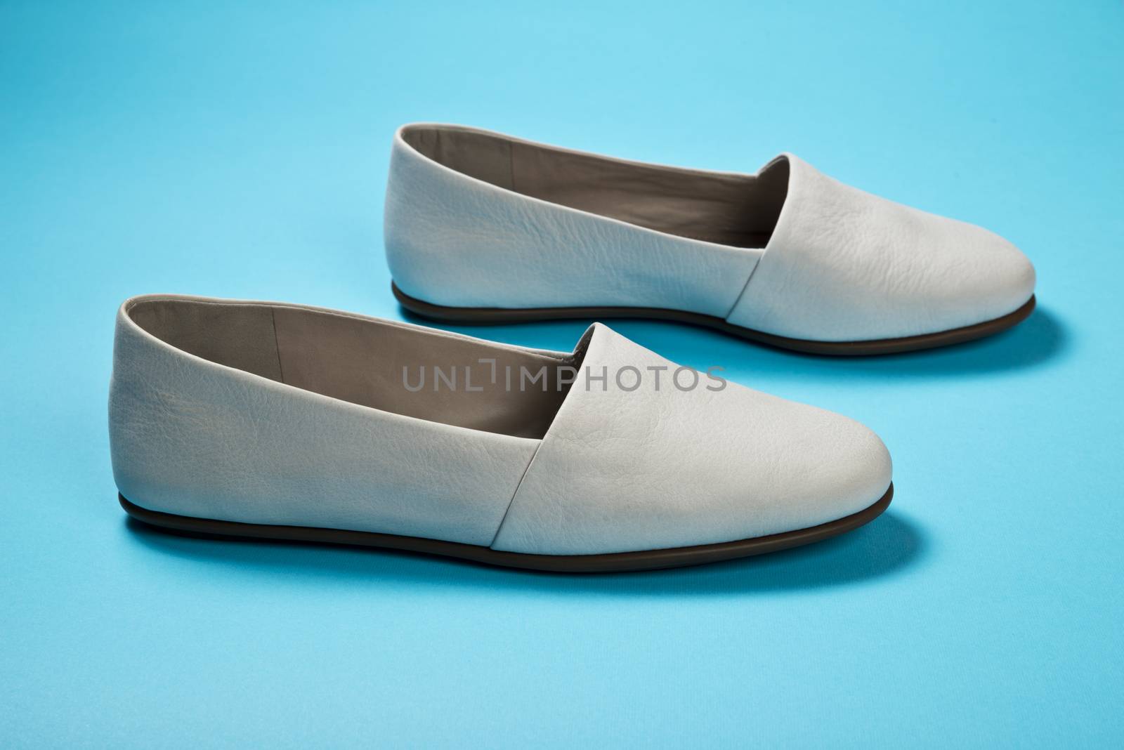 Woman casual gray leather shoes on blue