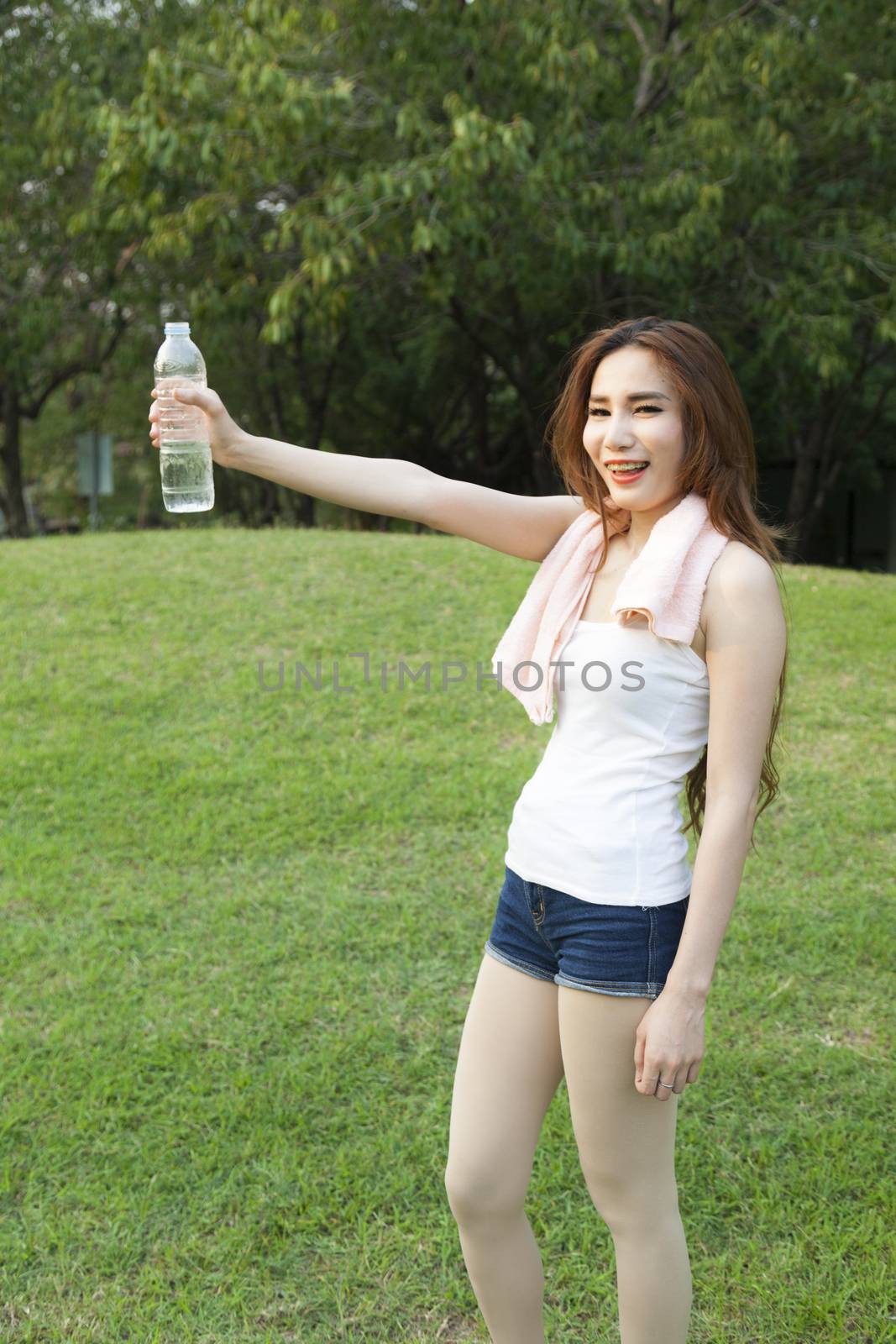 Female breaks standing and holding a bottle of water. by a454