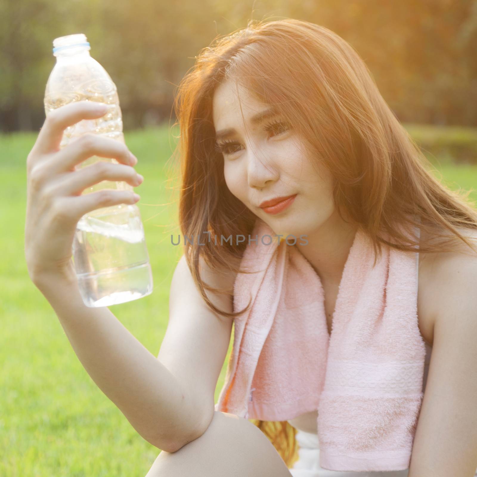 Woman Sitting and holding a bottle of water. by a454