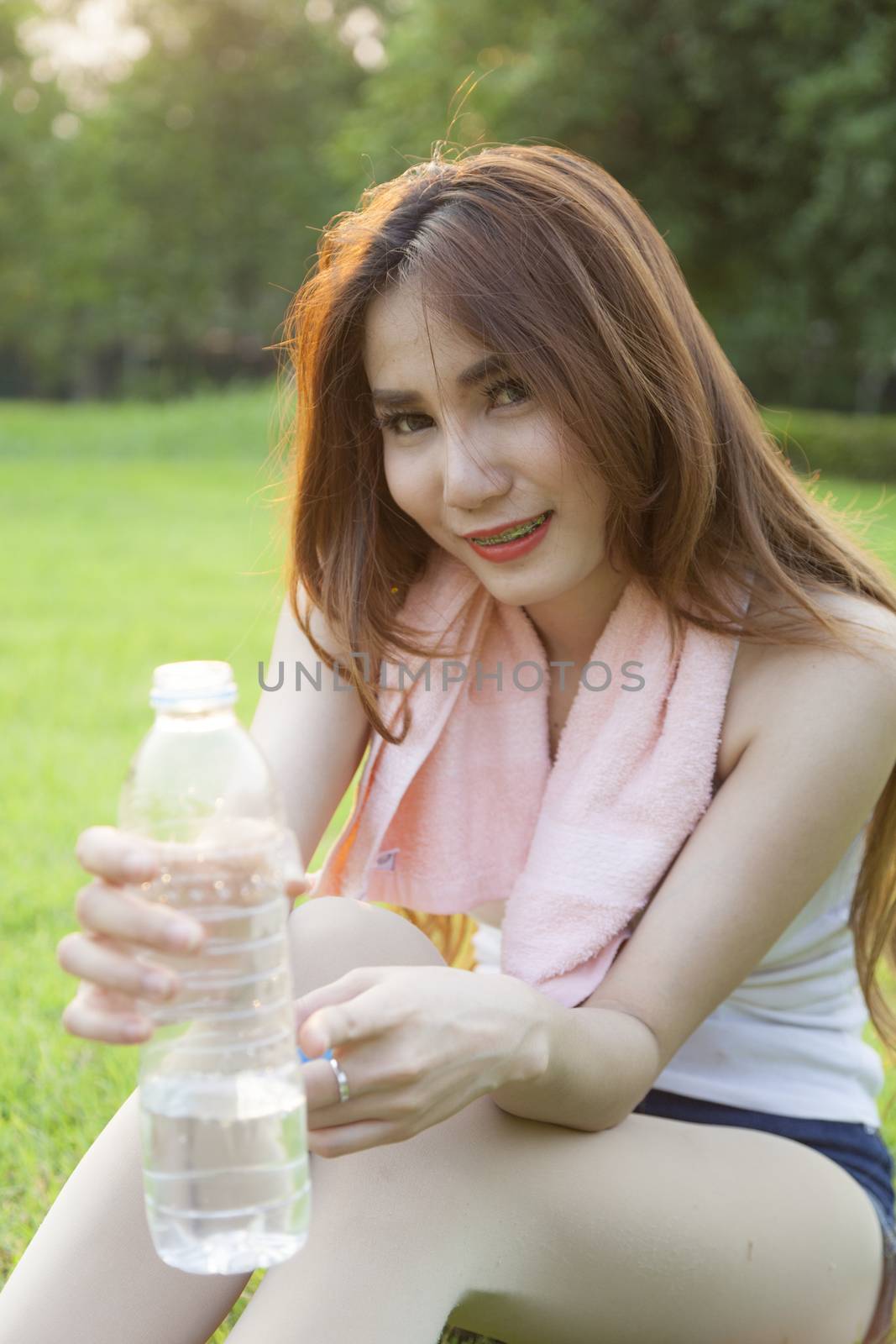 Woman holding a bottle of water and handed it to. by a454