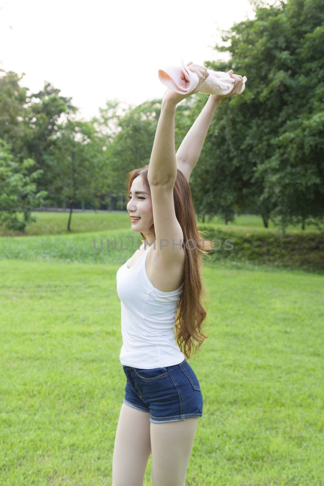 Woman warming up before exercise. on grass Within the park in the evening