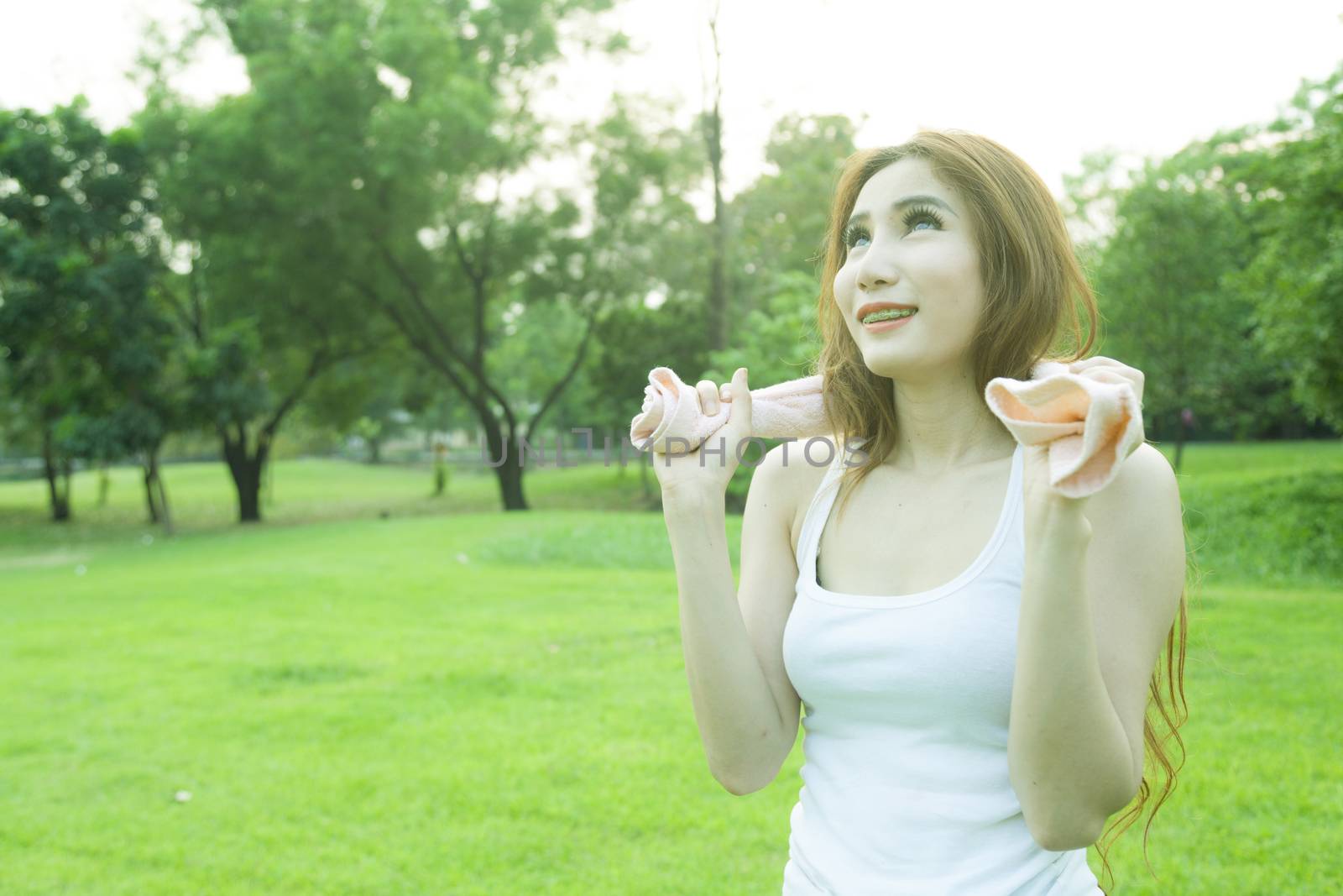 Woman standing rest after jogging. On lawn in the park